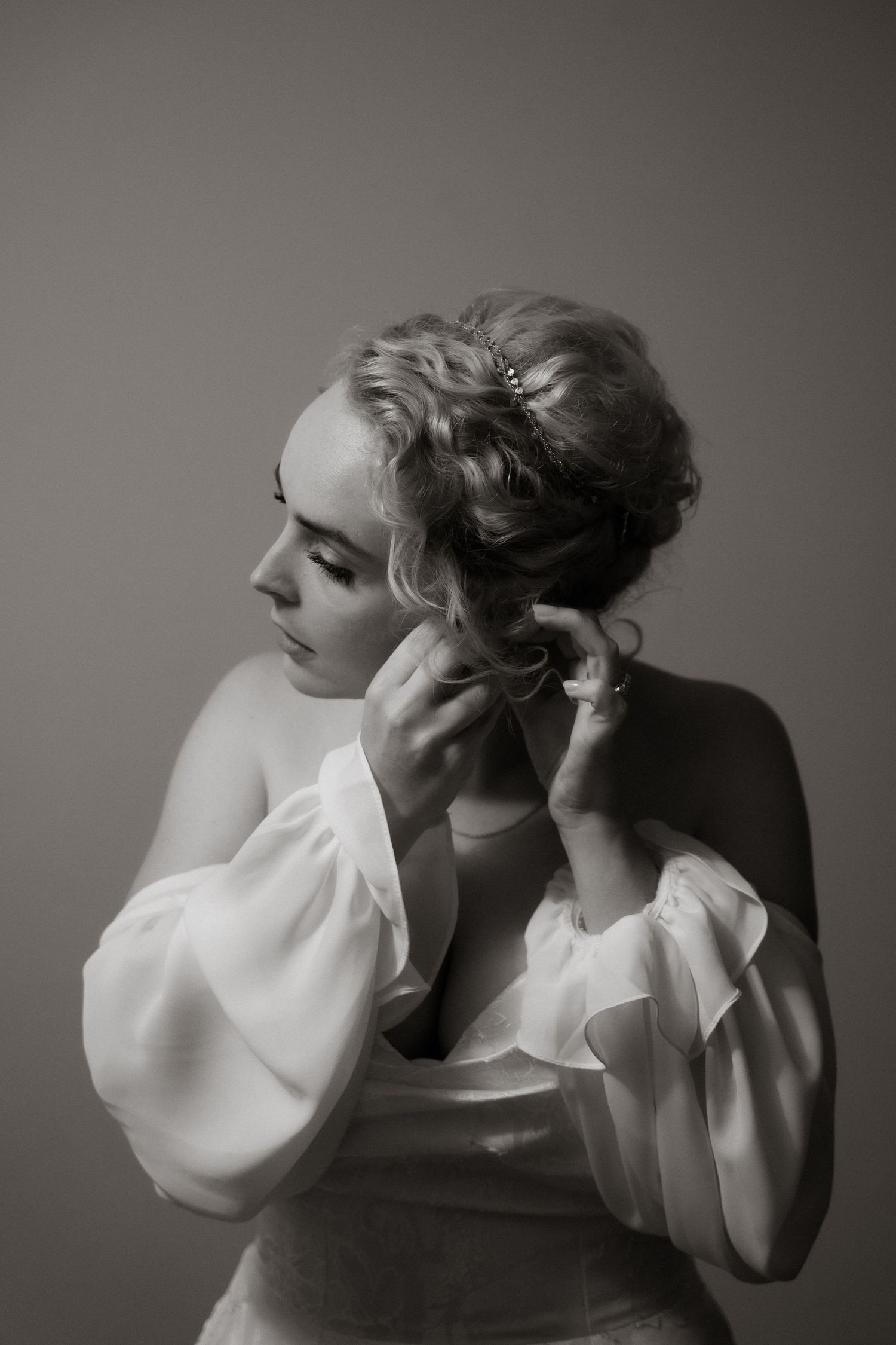 A series of black and white artistic photographs showing two figures in intimate poses wearing white flowing fabric.