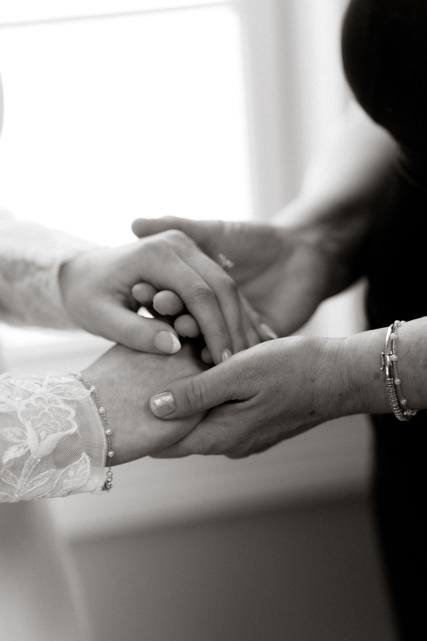 Black and white photo series showing hands reaching and holding each other in a romantic sequence.