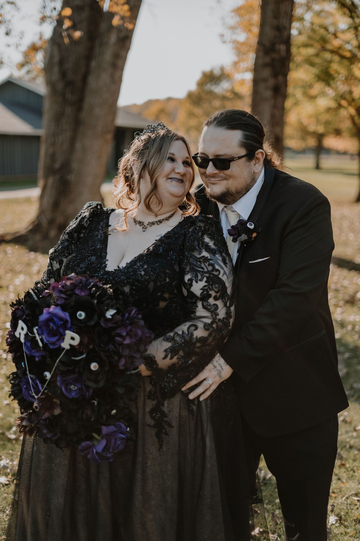 Romantic fall wedding portraits with couple embracing among autumn foliage.