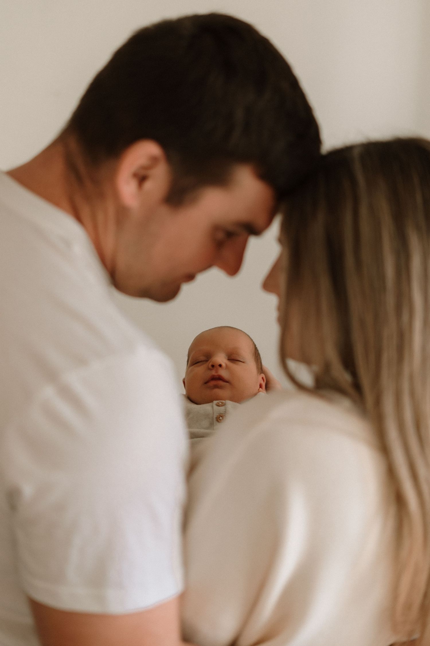 Intimate newborn photography session with soft lighting and neutral tones.