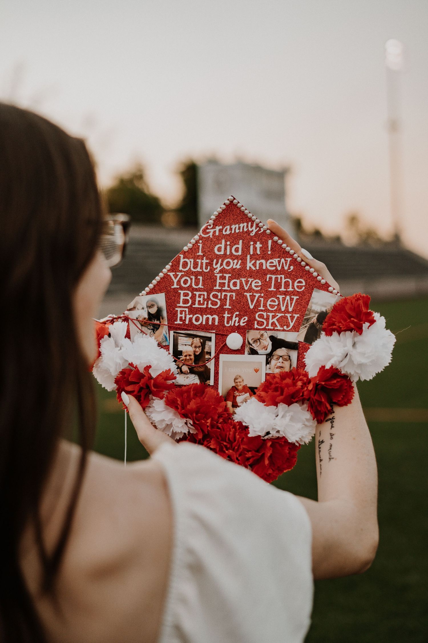 Red graduation cap decorated with flowers and text reading 