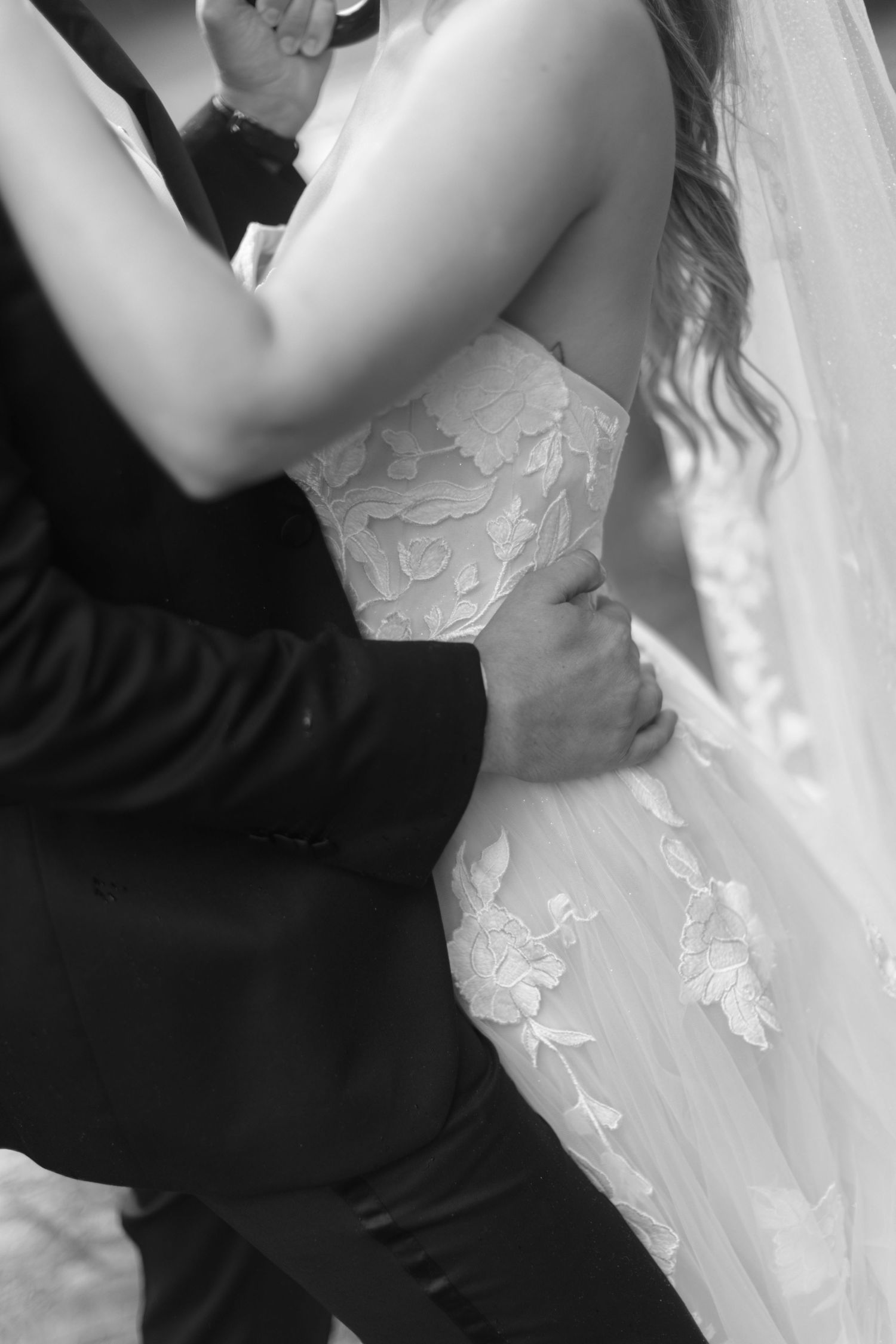 Intimate black and white wedding photo sequence of couple embracing in formal dress and white gown.