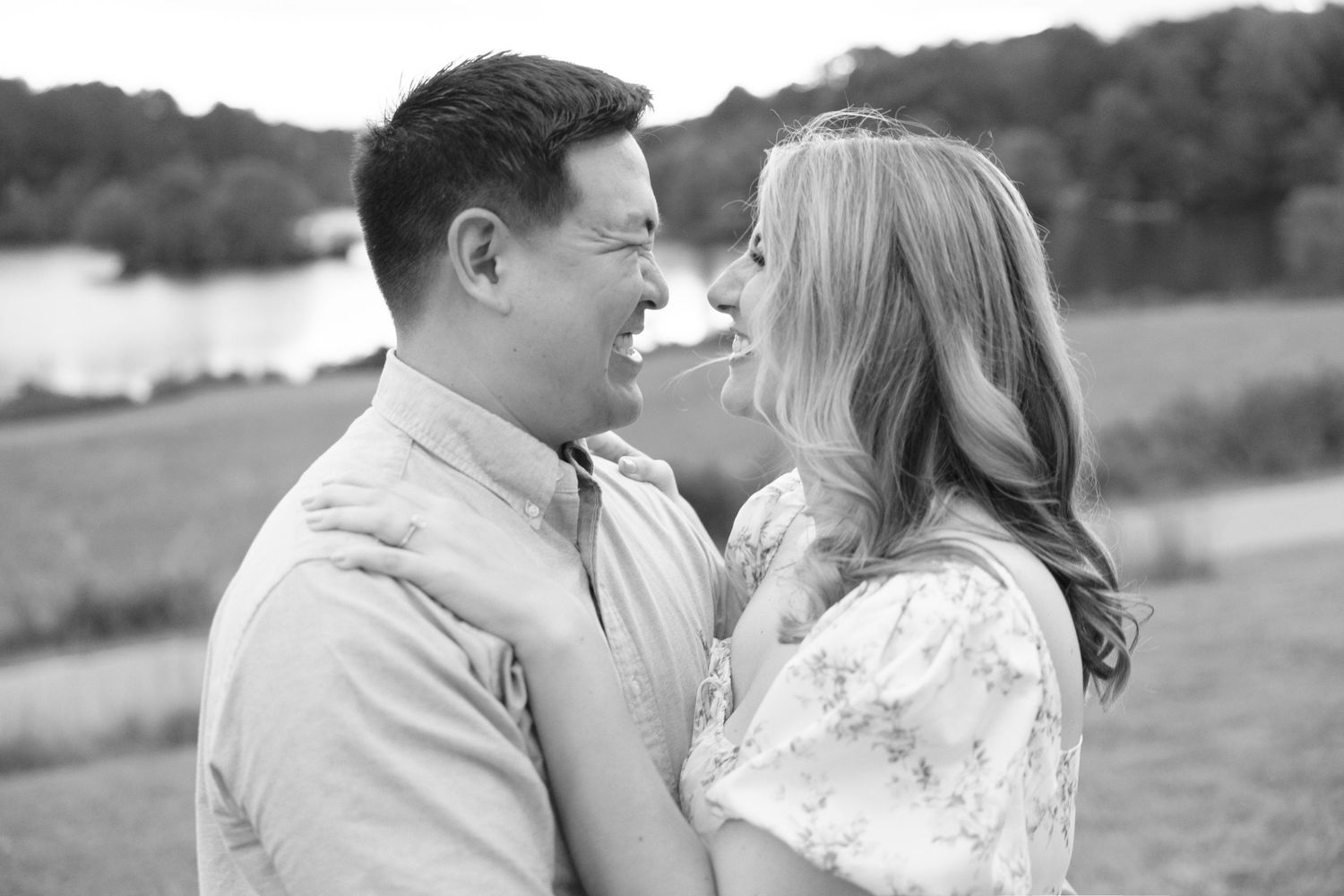 Black and white portrait of a couple sharing a tender moment outdoors.