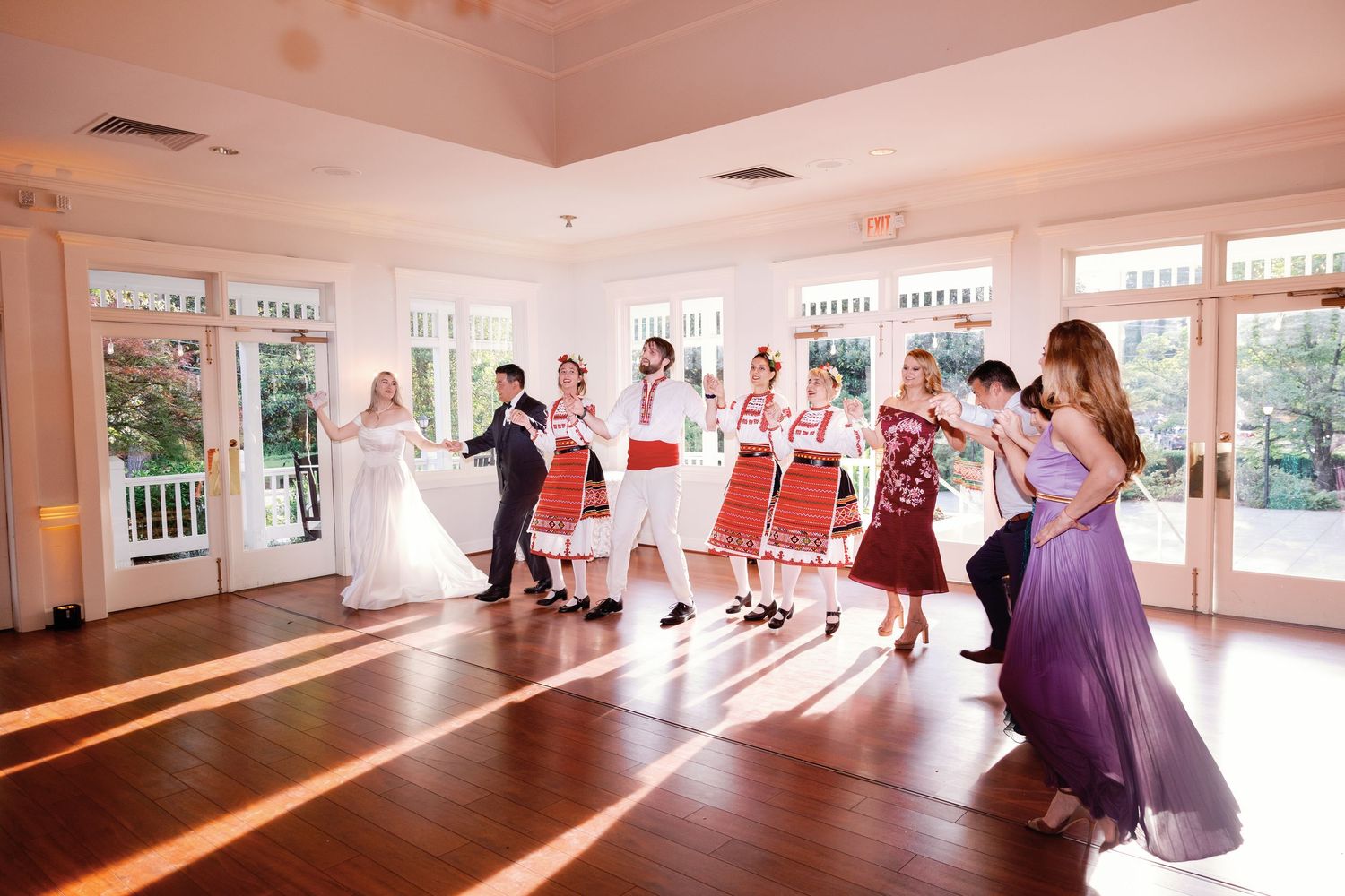 Wedding reception dance floor filled with guests in formal attire.
