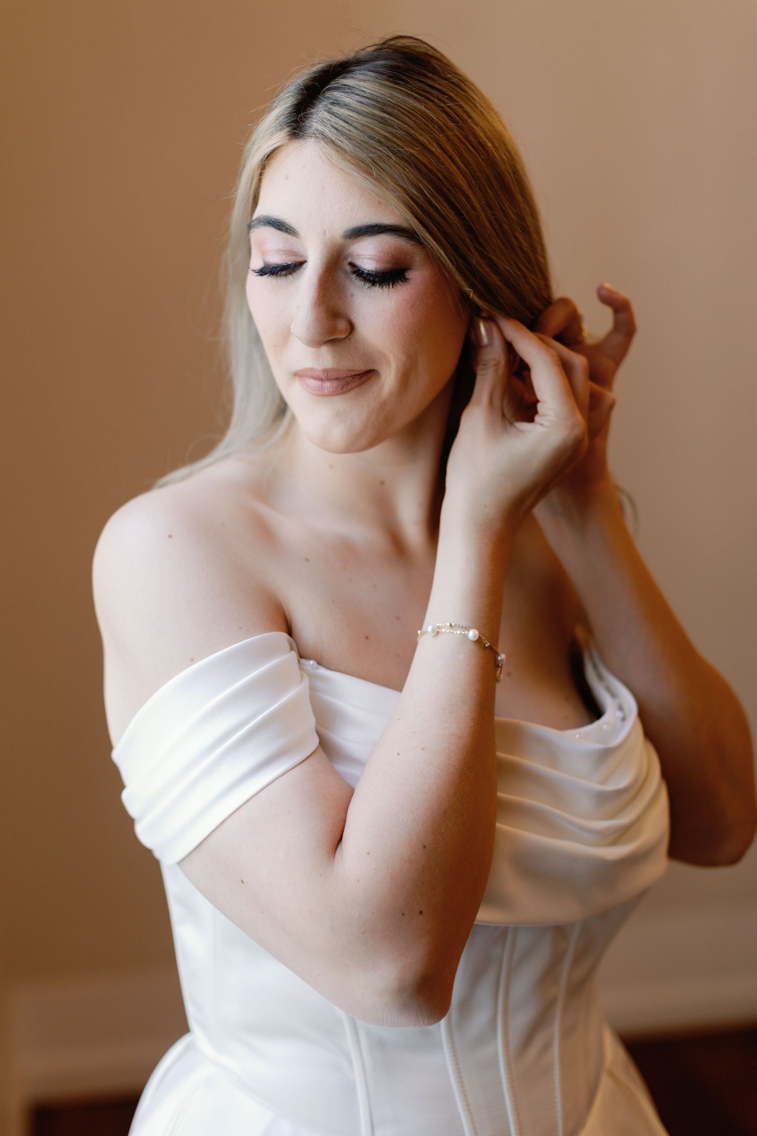 Artistic boudoir photography series in warm tones featuring a white off-shoulder dress.