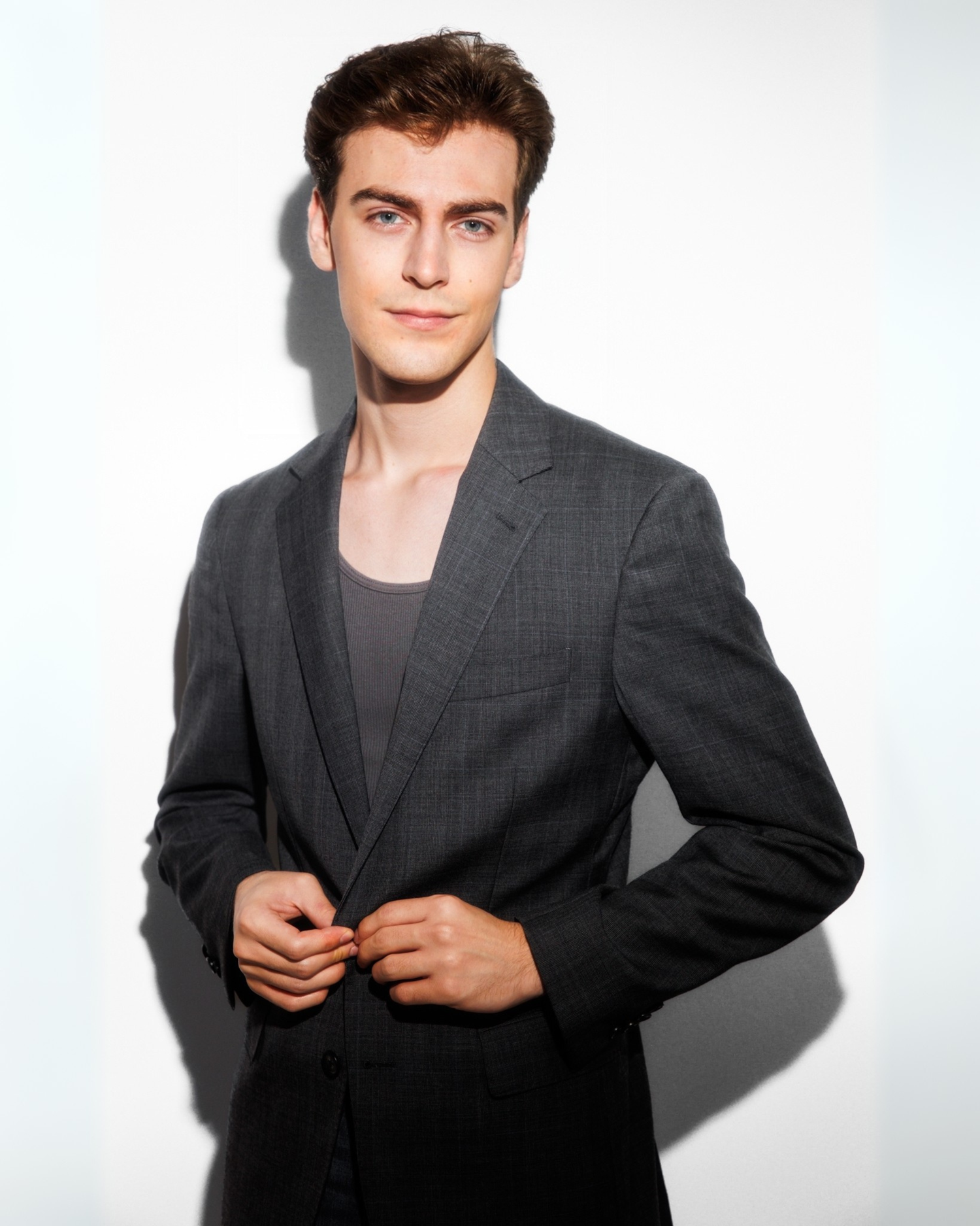 Professional studio portrait of a man in a dark suit jacket.