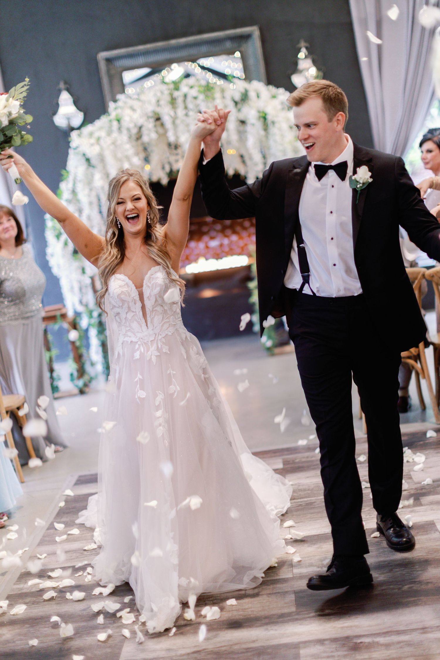 Joyful wedding celebration with flower petals falling as the couple dances on their special day.