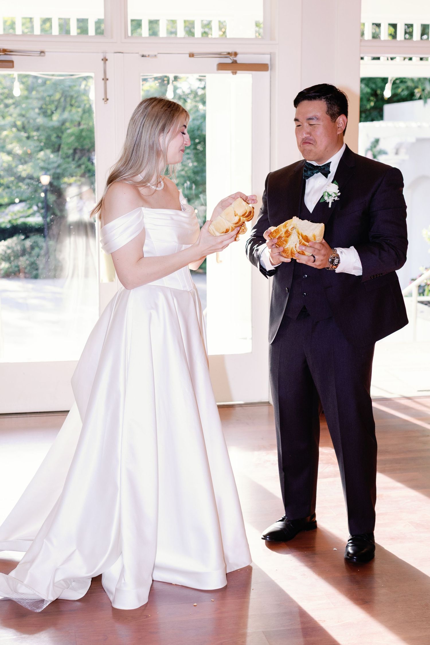 Wedding couple enjoying sandwiches during reception on covered porch.
