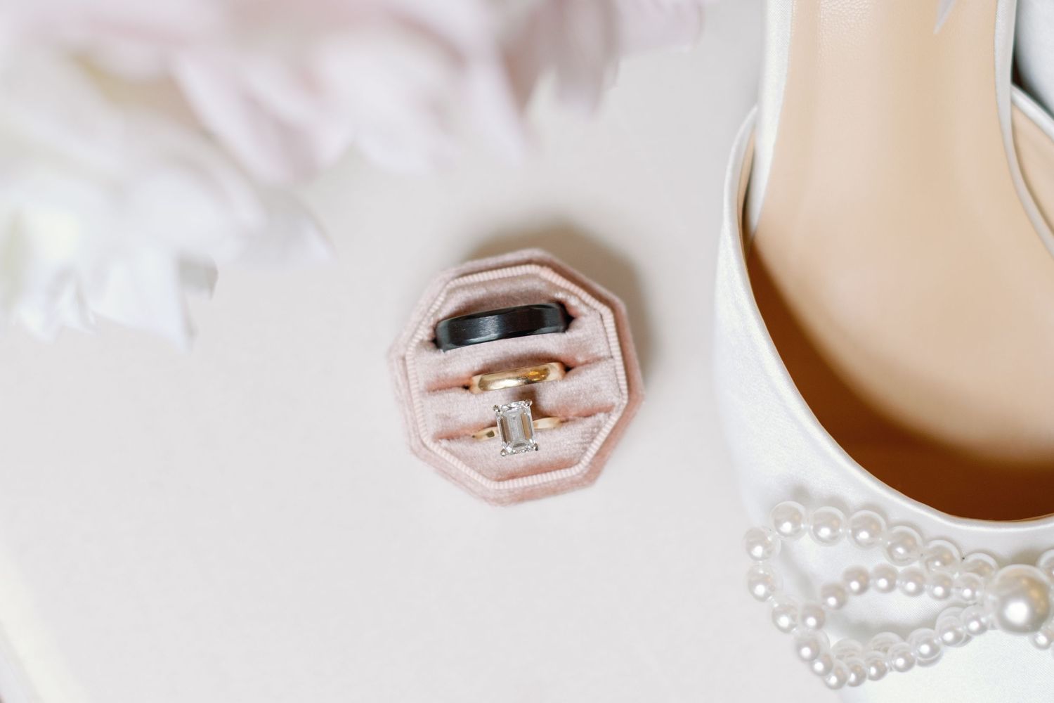 Wedding details featuring elegant white rings and delicate decor in soft tones.