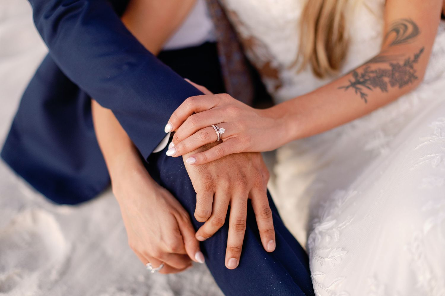 Close-up of hands showing wedding rings and jewelry details.