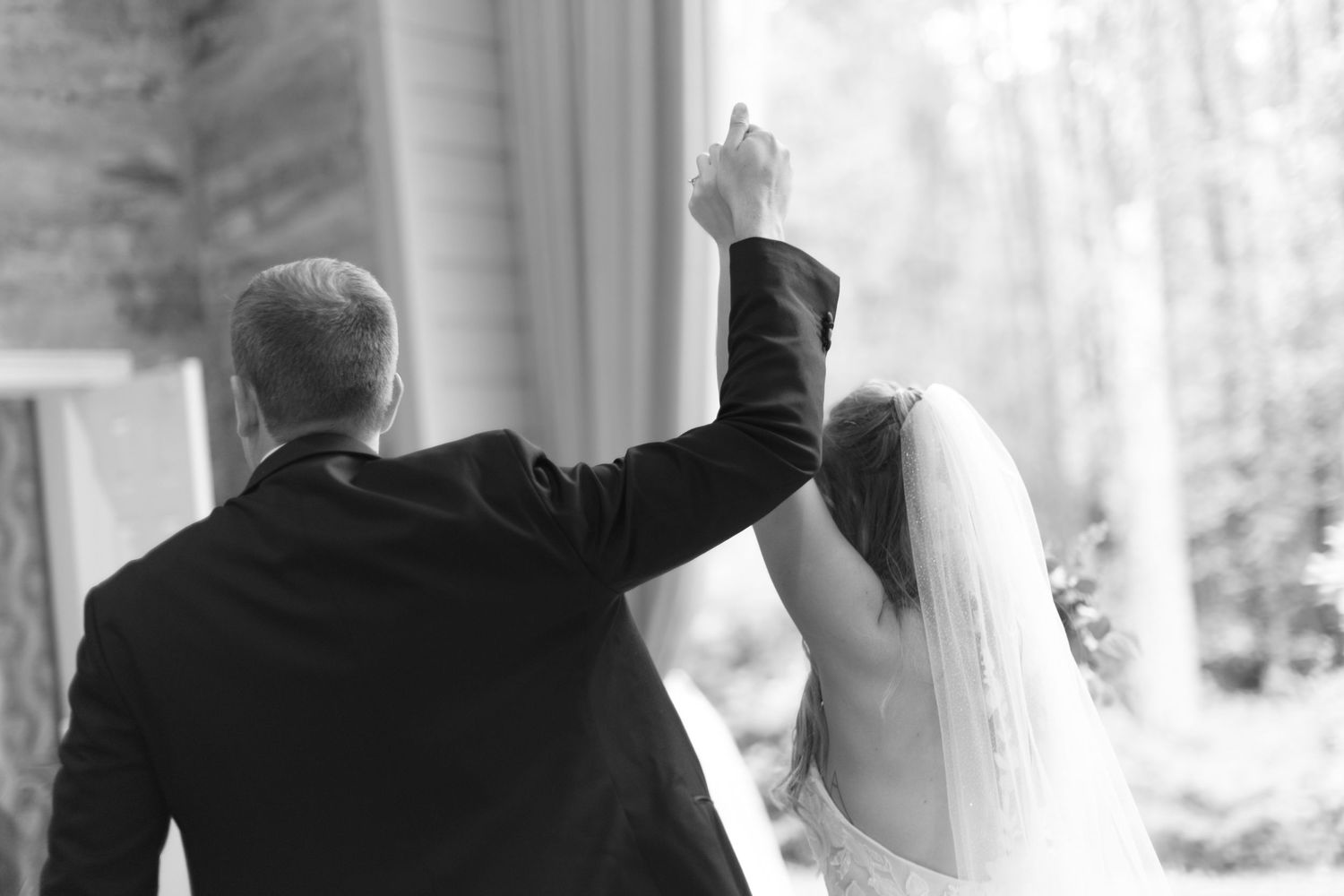 Candid wedding ceremony moments photographed through window panes with natural lighting.
