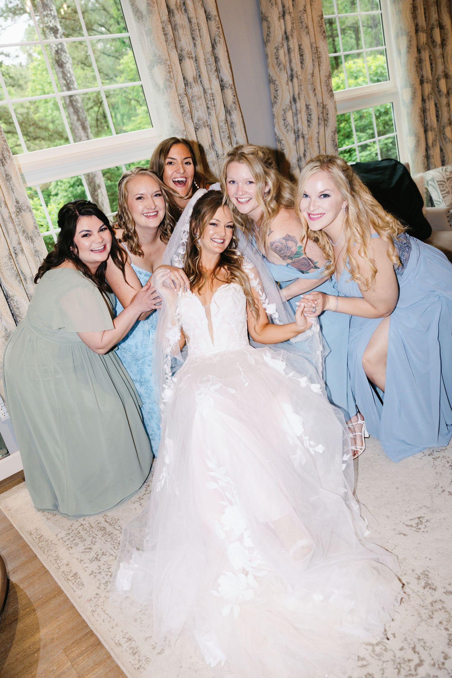 Bridesmaids in light blue dresses celebrate joyfully with the bride.