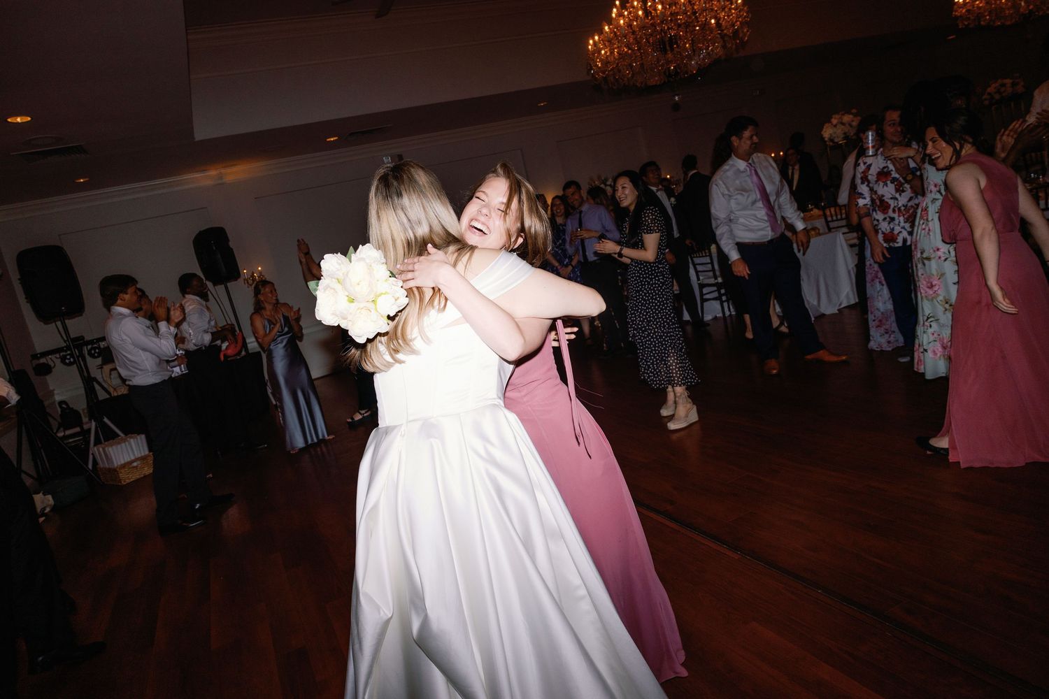 Wedding reception dance floor filled with celebrating guests in formal attire.