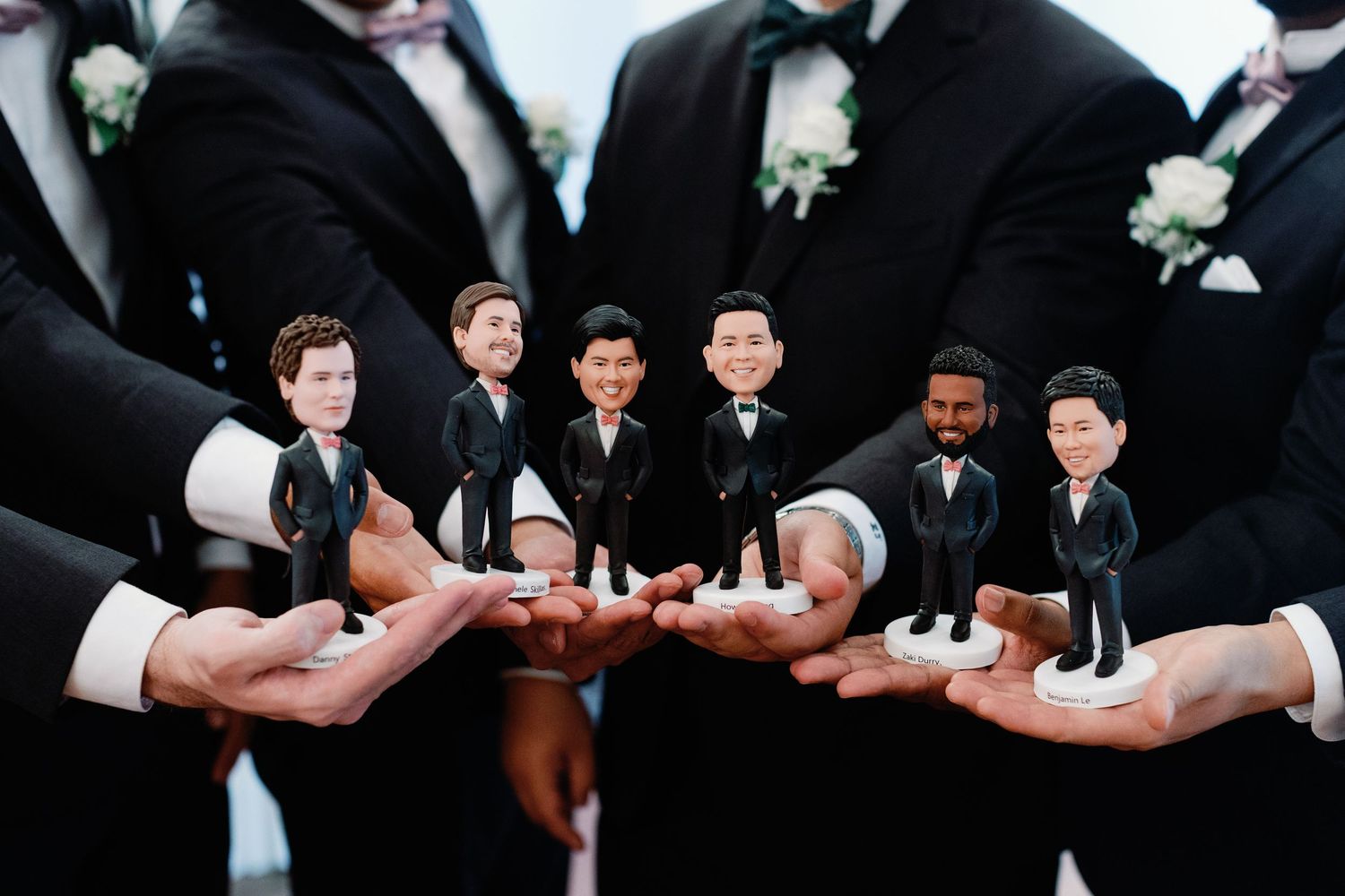 Groomsmen share a lighthearted moment while showing off their matching socks at a wedding celebration.