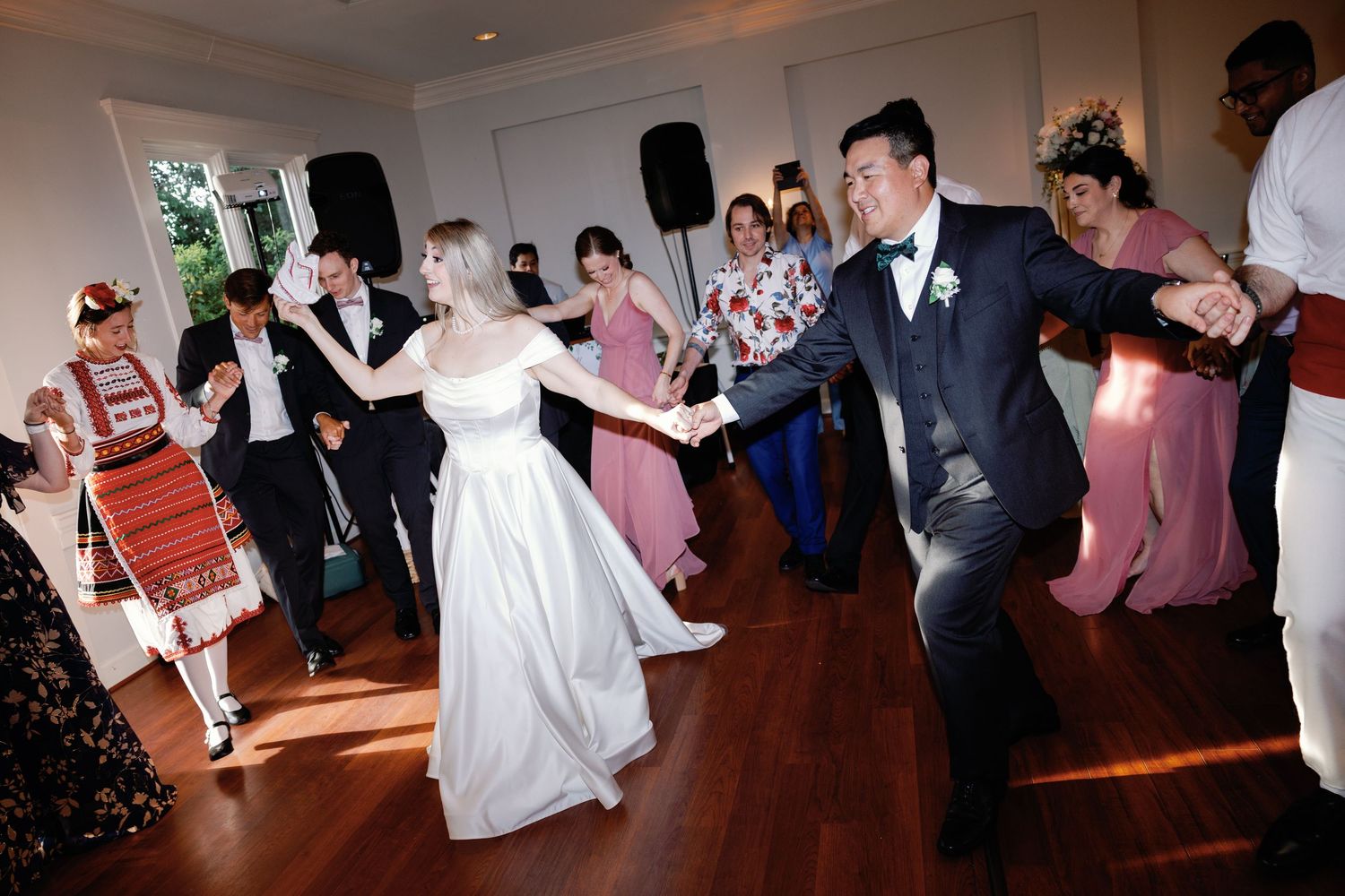Lively wedding reception dancing scene with guests in formal attire.