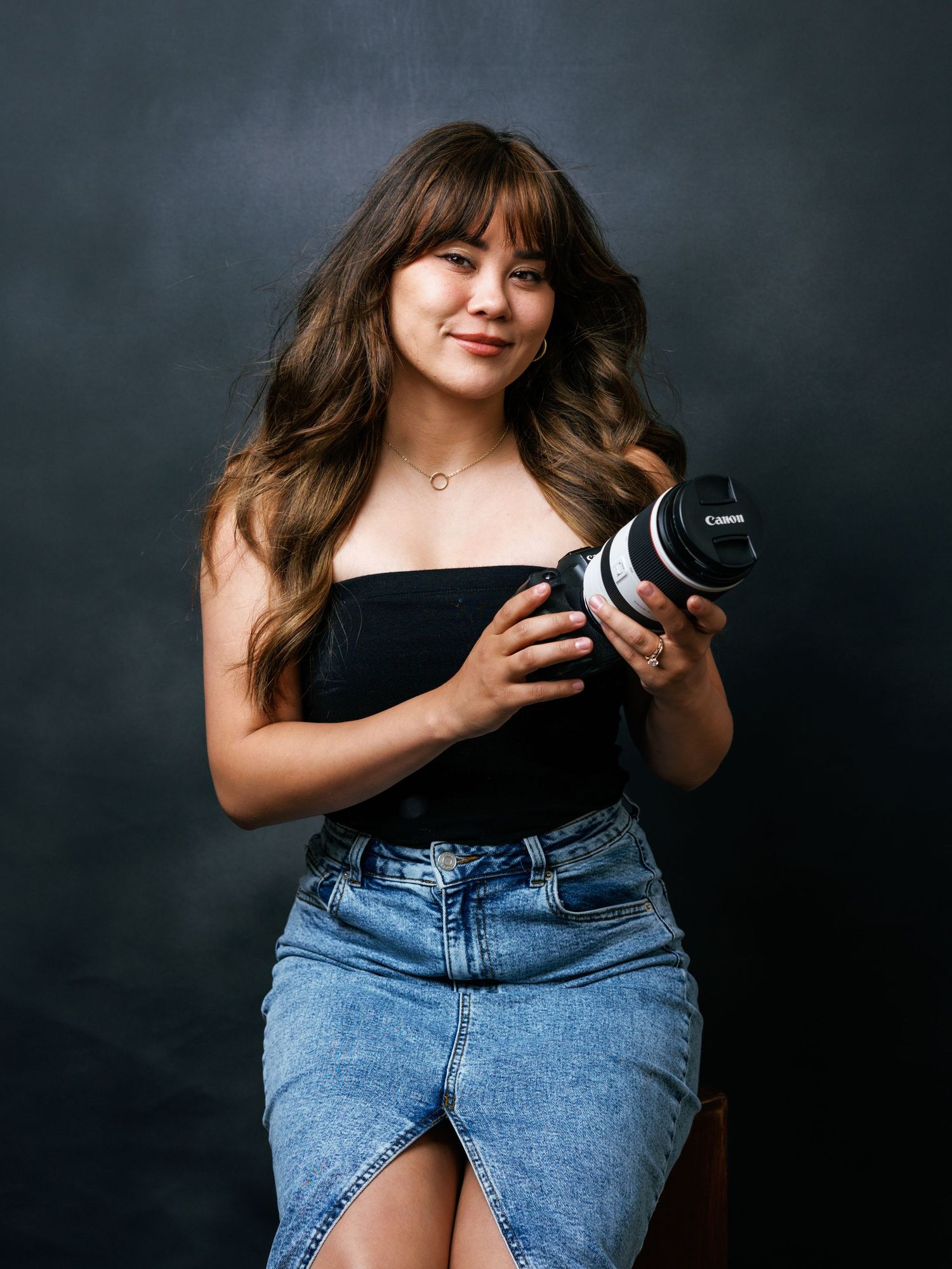 Creative portrait series of photographer holding camera in casual denim outfit.