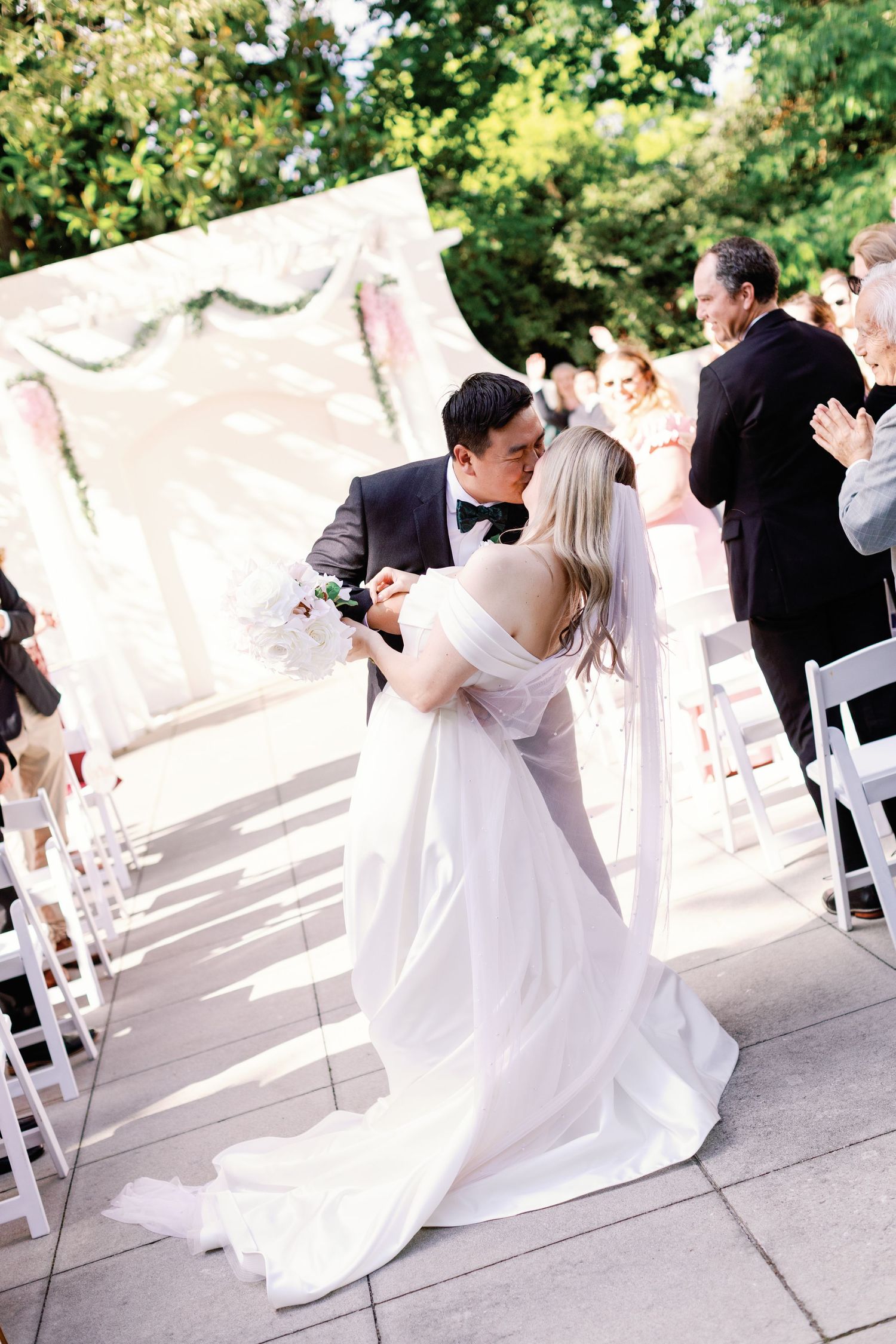 Wedding couple shares romantic dance moments during outdoor ceremony.