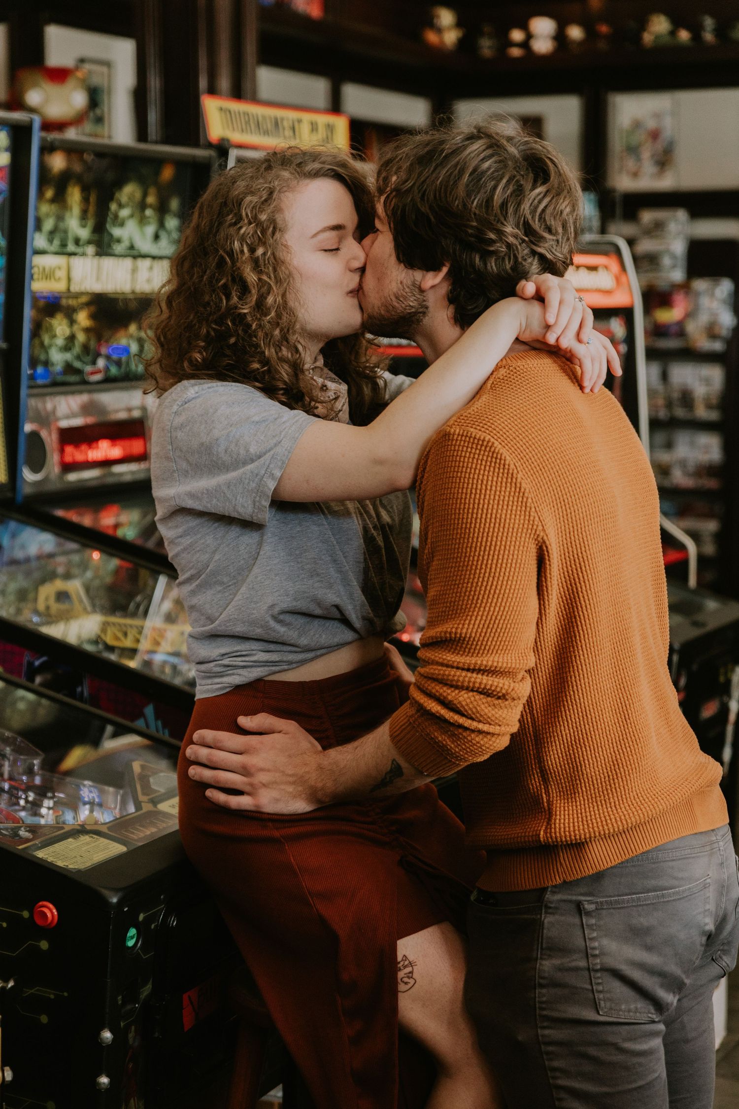 Romantic moment between a couple sharing an intimate embrace among arcade games.