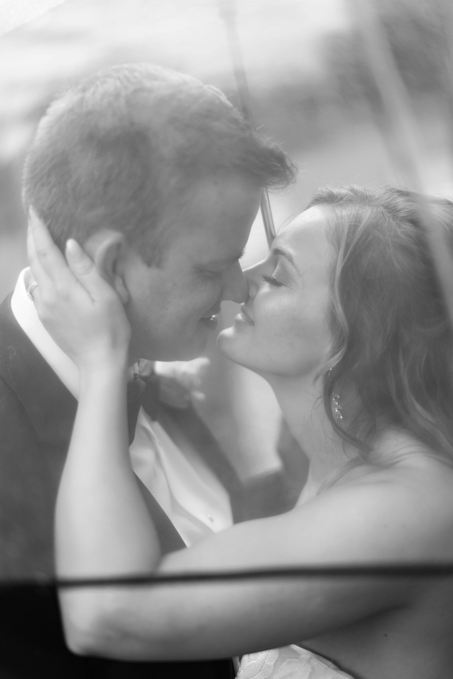 Black and white romantic wedding photo sequence showing tender kiss between couple in formal attire.