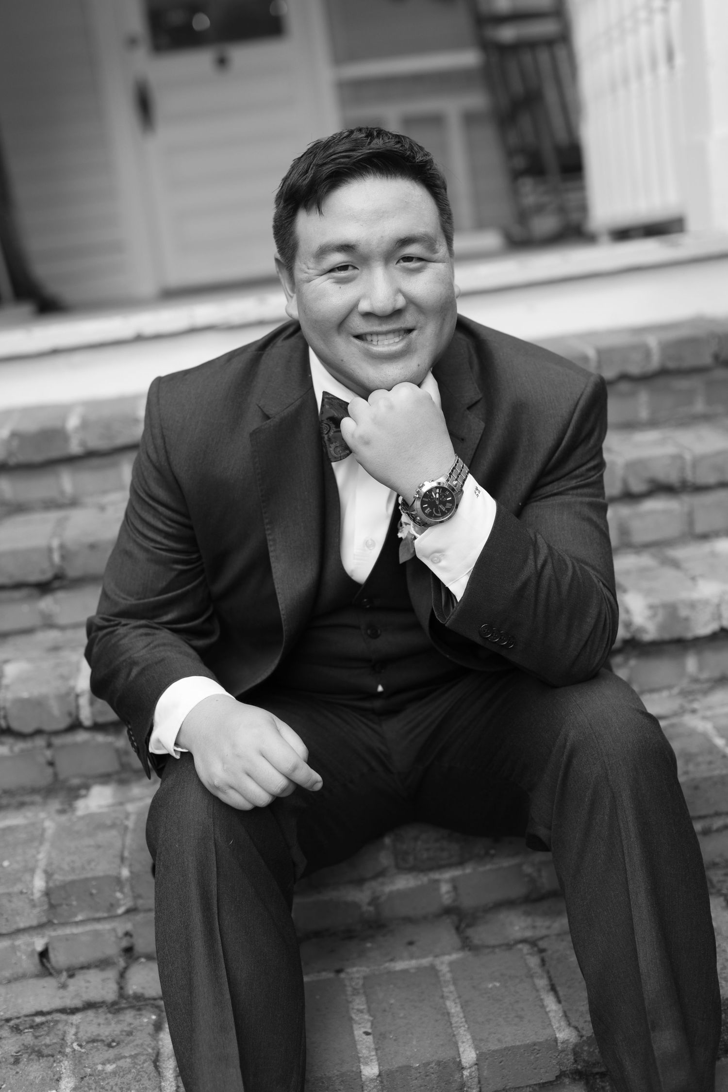 Black and white portrait on brick steps creates dramatic wedding day composition.