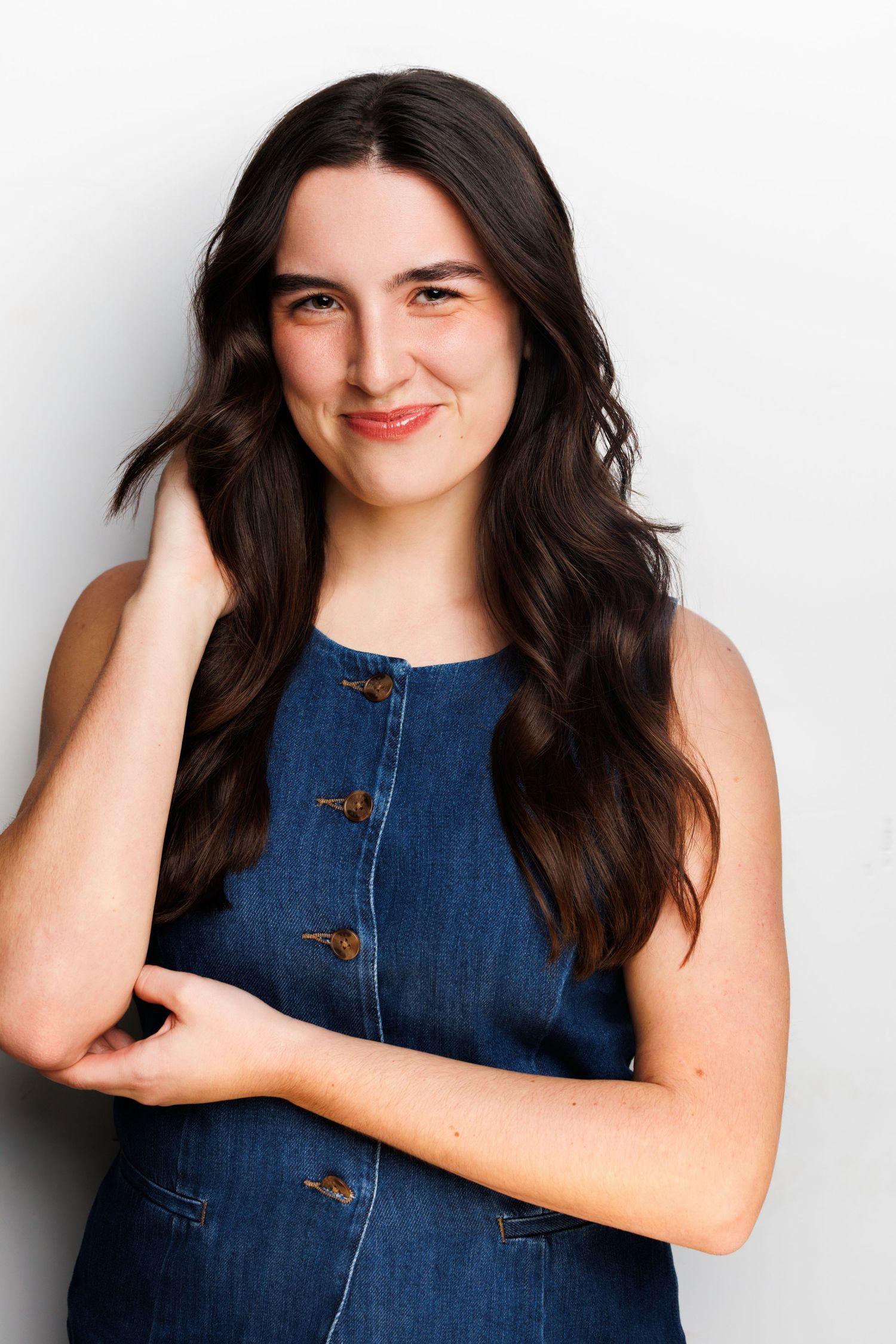 Four sequential portraits of a person wearing a denim sleeveless top against a white background.