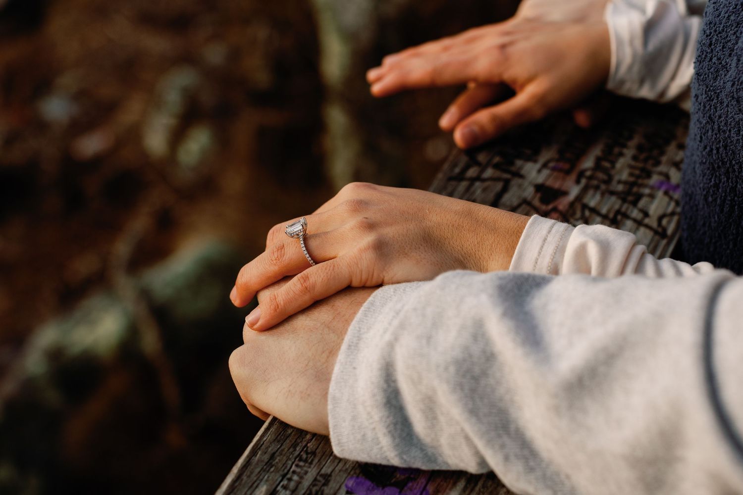 Close-up shots of hands tenderly touching against a dark background.