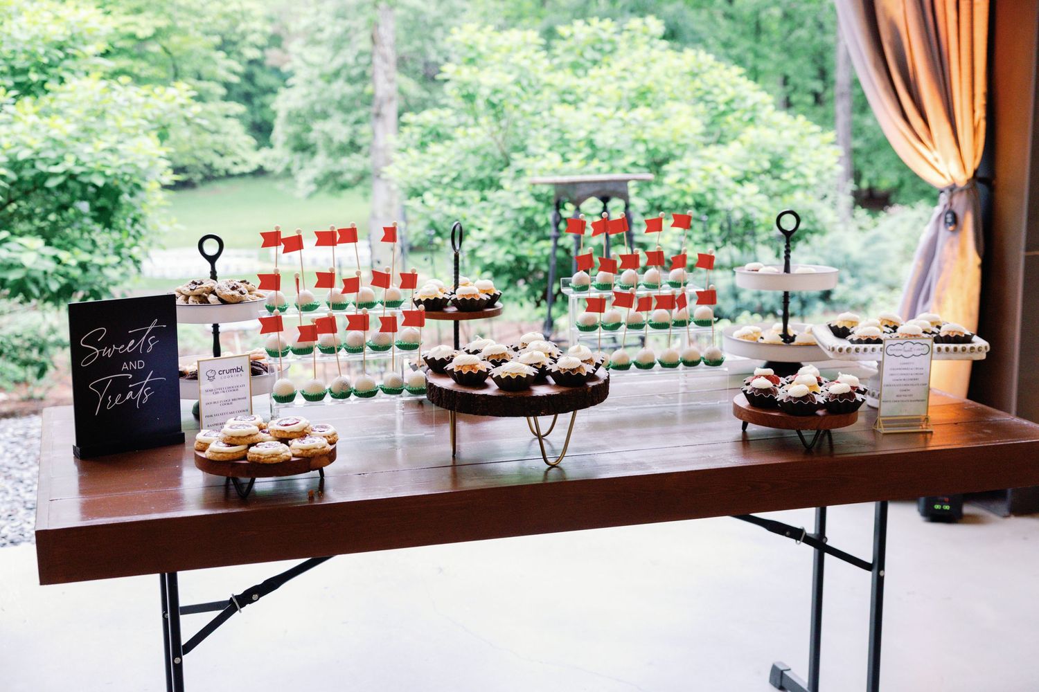 Wedding reception venue setup with elegant tables and decor overlooking green outdoor scenery.