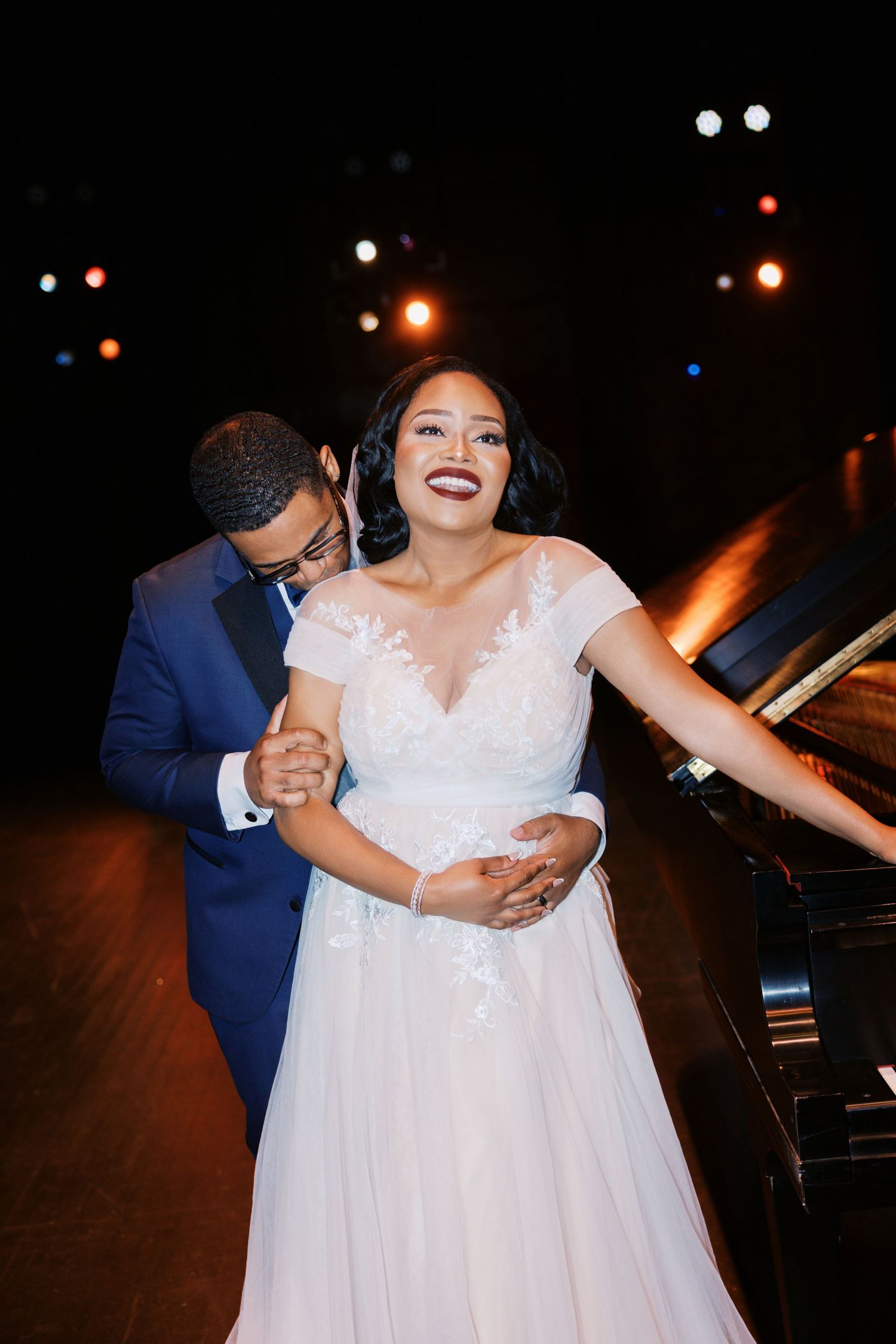 Wedding couple dancing together in an intimate moment under stage lights.