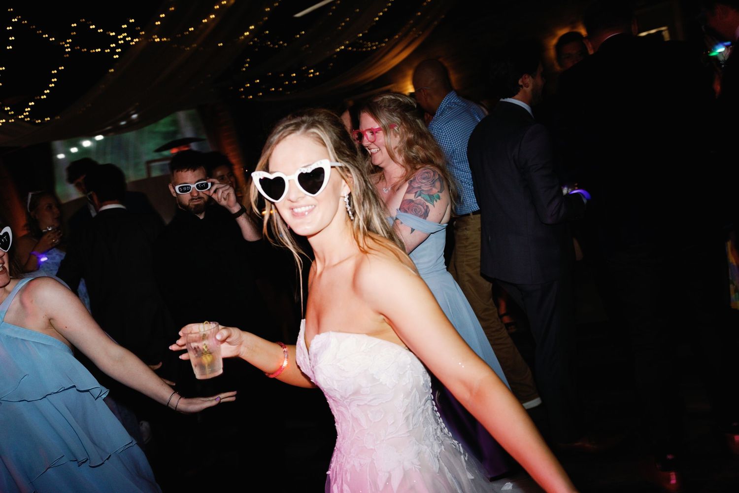 Lively dance floor celebration during nighttime wedding reception.