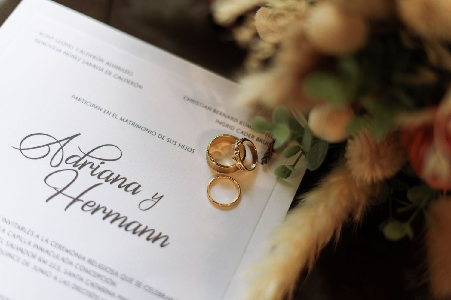 Flatlay of wedding rings and invitations—curated for a luxury destination celebration.