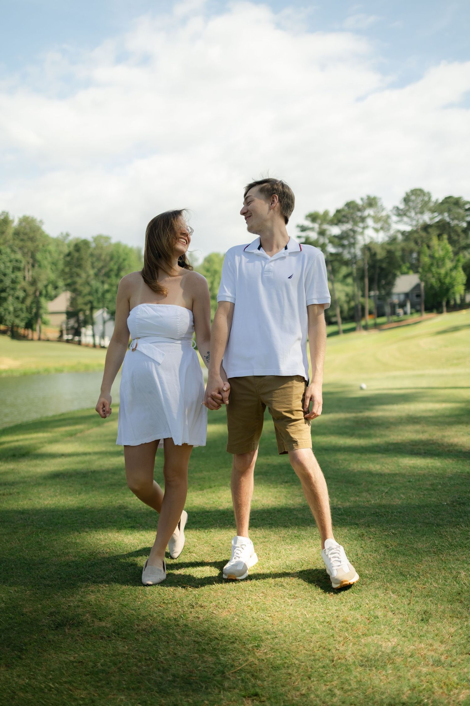 A couple in white and brown outfits sits together on a sunny golf course, captured in multiple romantic poses.