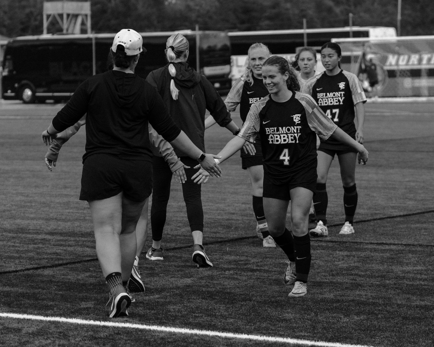 Athletes running in formation during soccer practice on field.