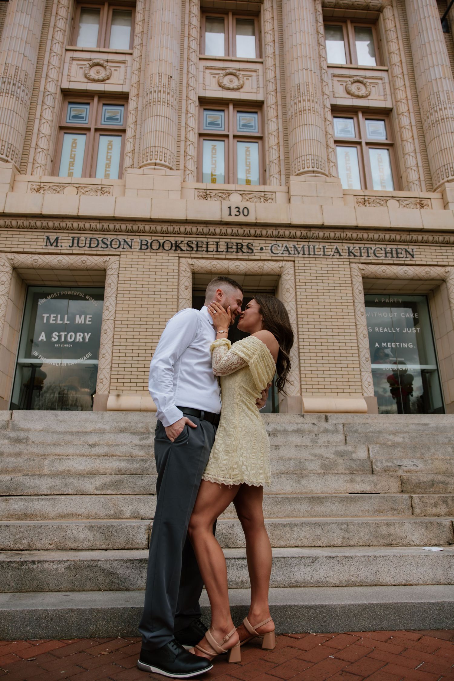 Couple sharing a romantic kiss on steps outside M. Judson Booksellers in Greenville, SC.