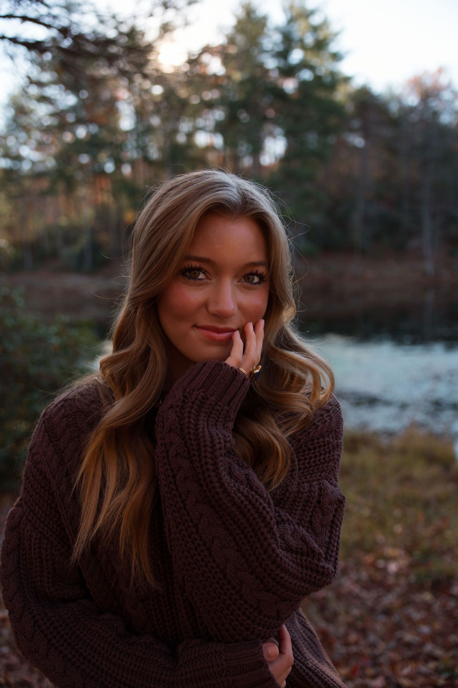 Portrait series in brown sweater against autumn forest background.