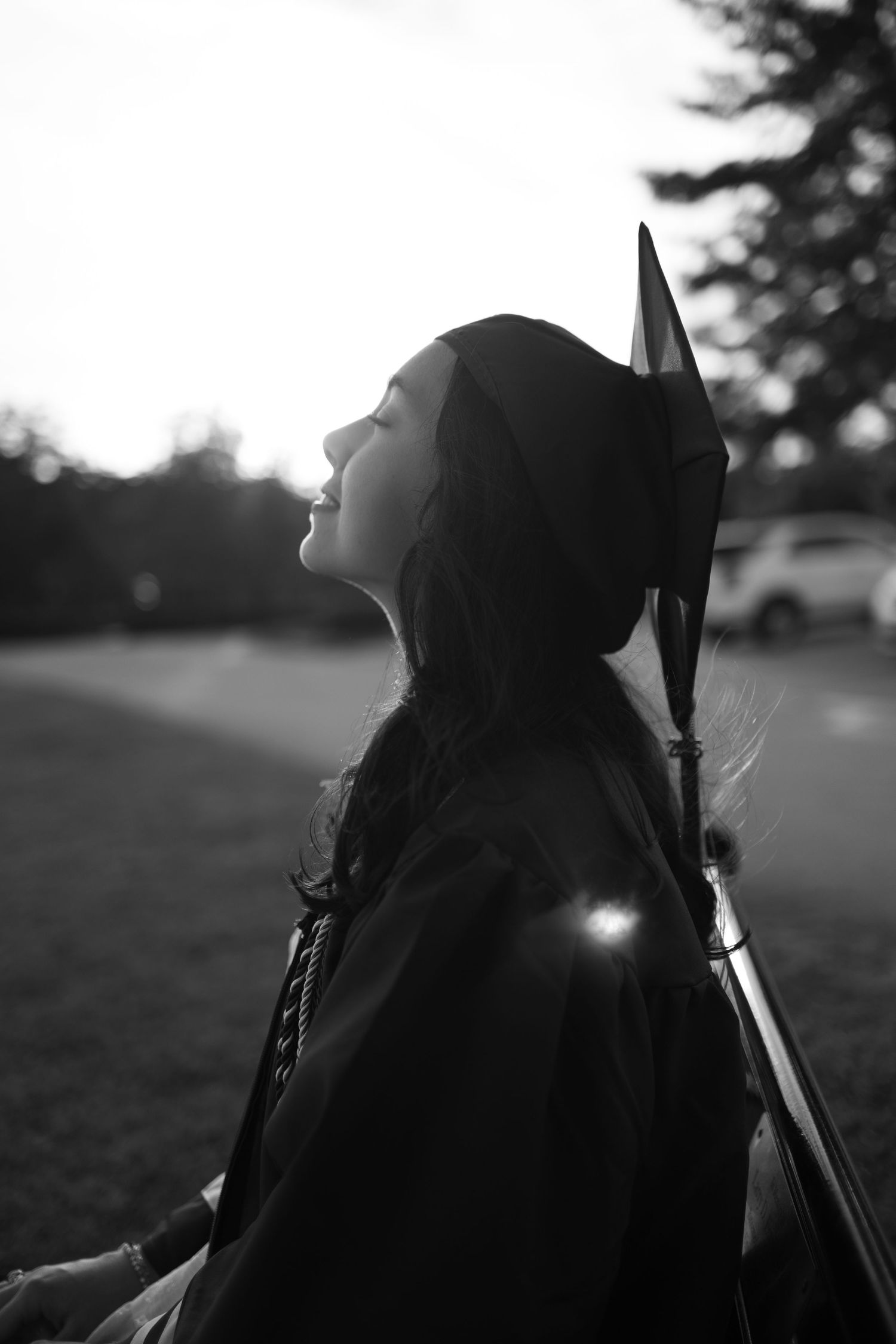 Silhouette of graduation cap against sunset sky.
