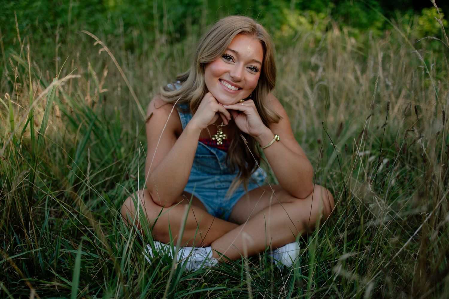 Summer portrait session in tall grass and wildflowers.
