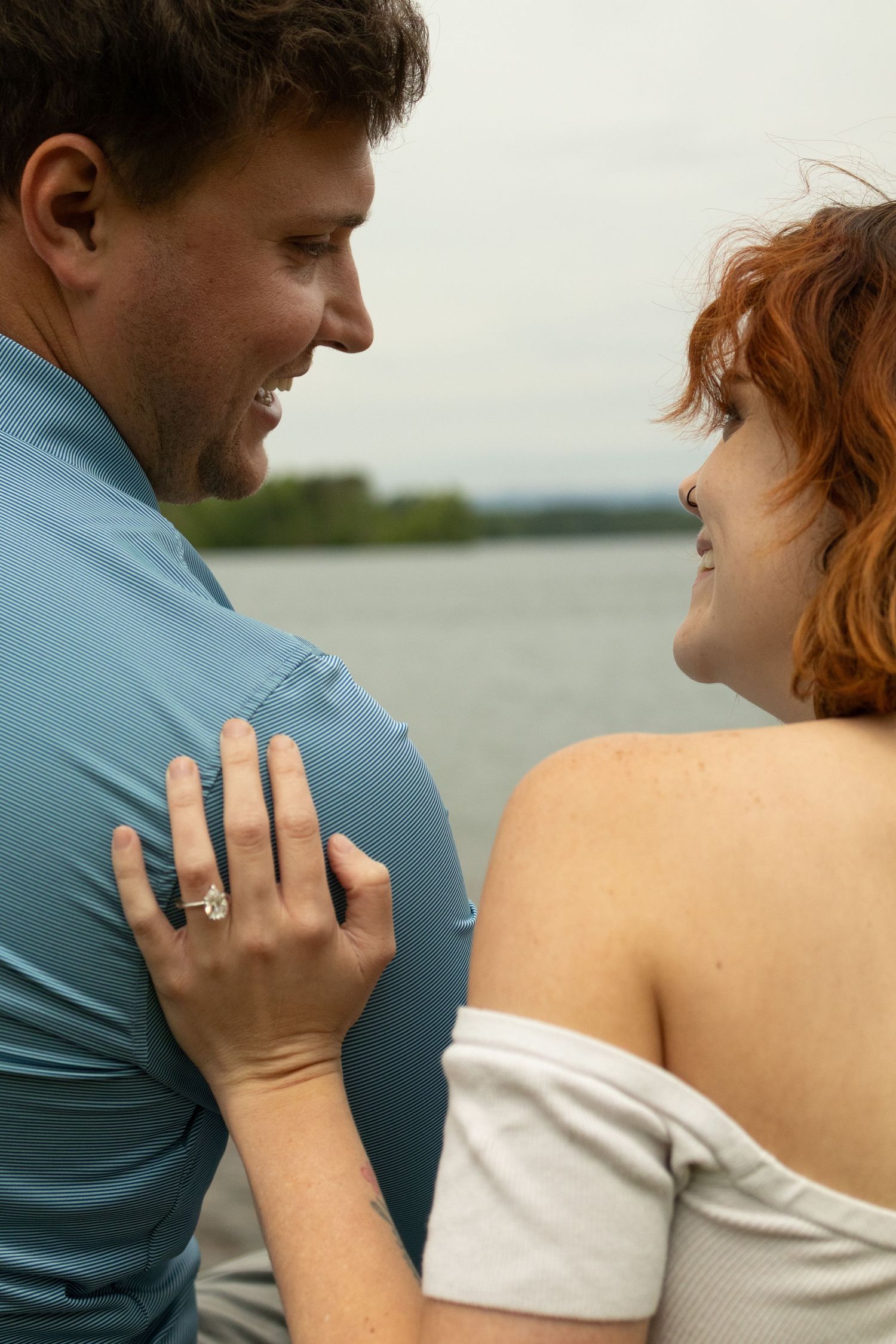 An intimate close-up of a couple embracing by the water.