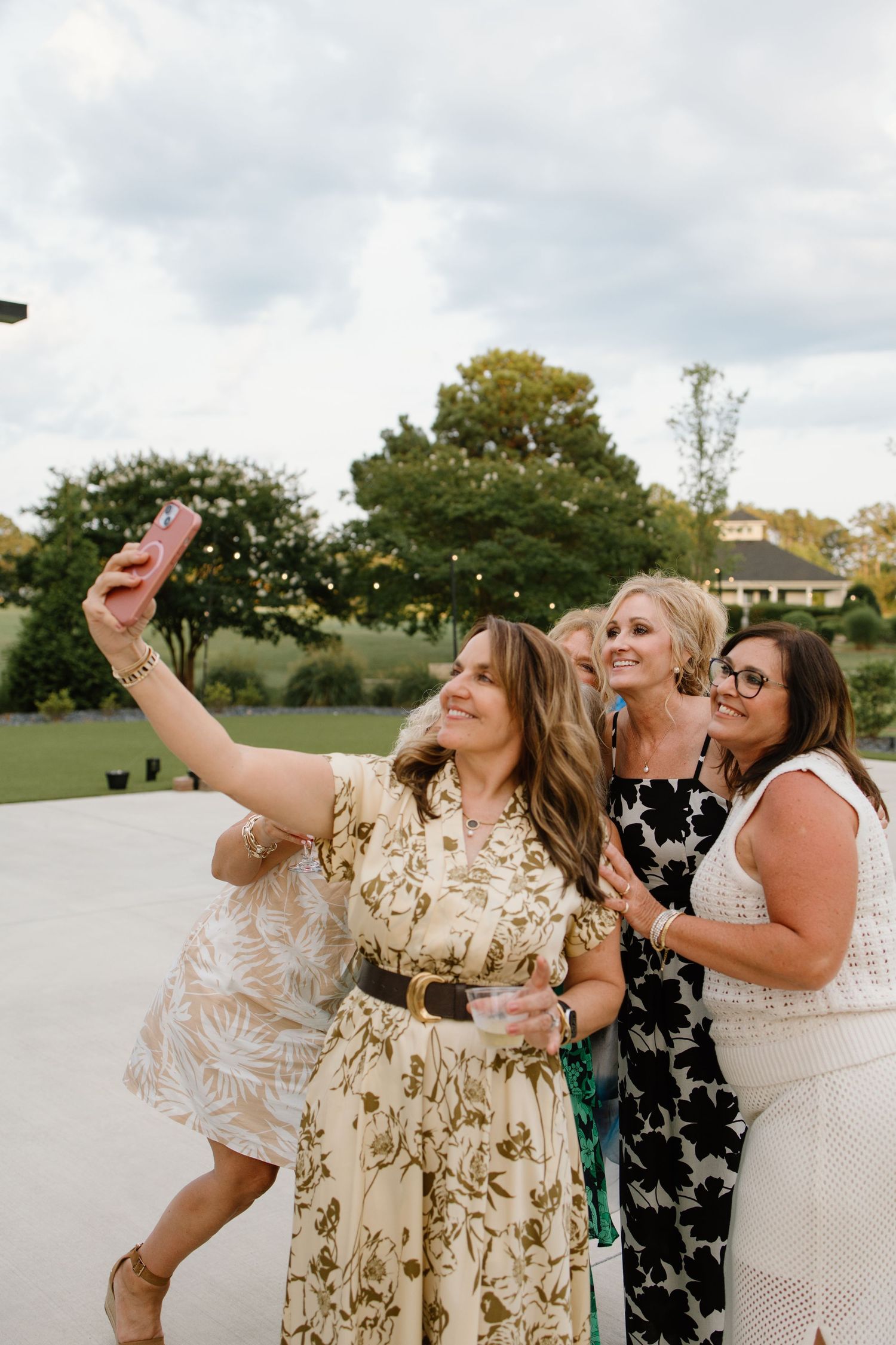 Friends taking a selfie together during an outdoor celebration.