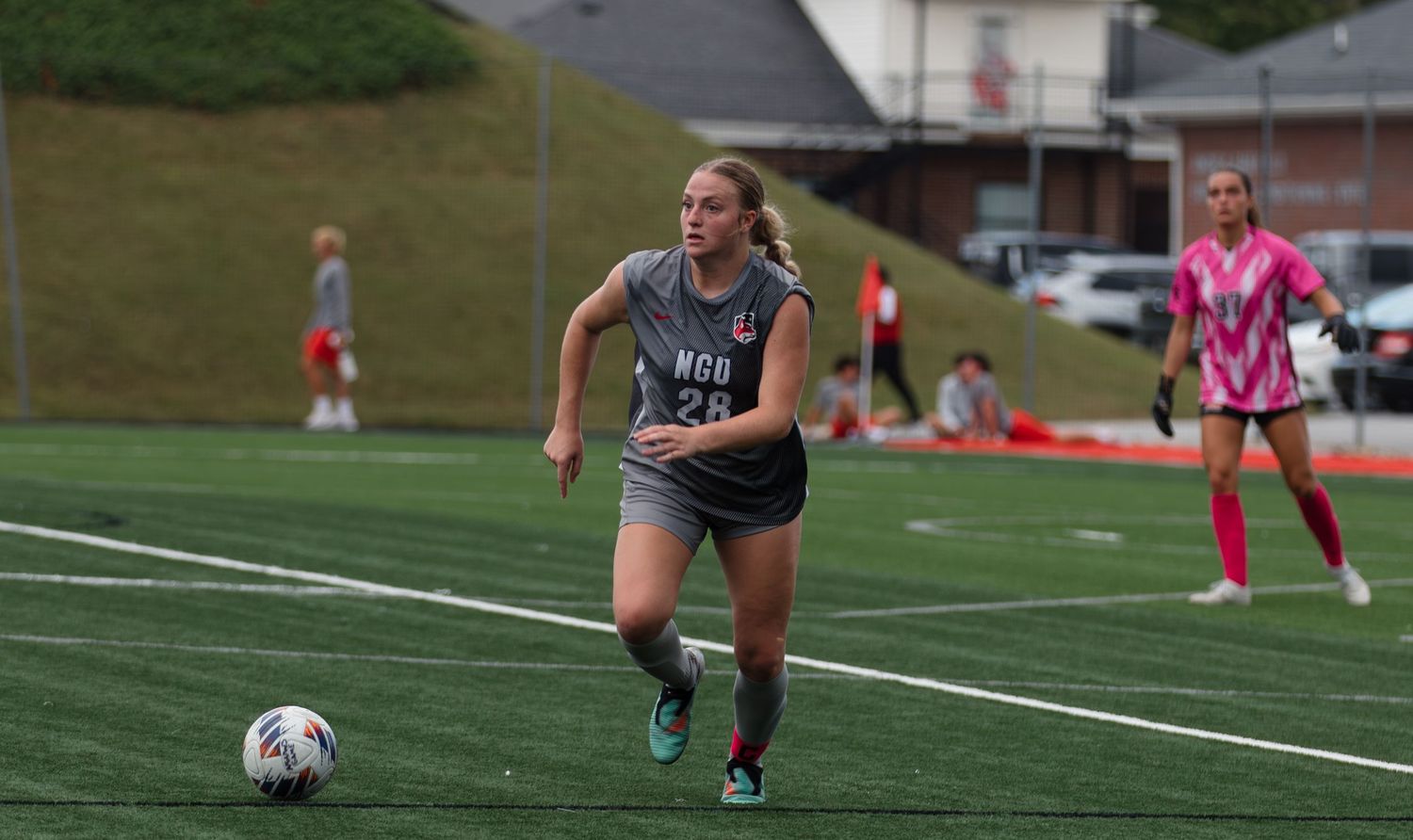 Athletes practicing soccer drills on an outdoor turf field.