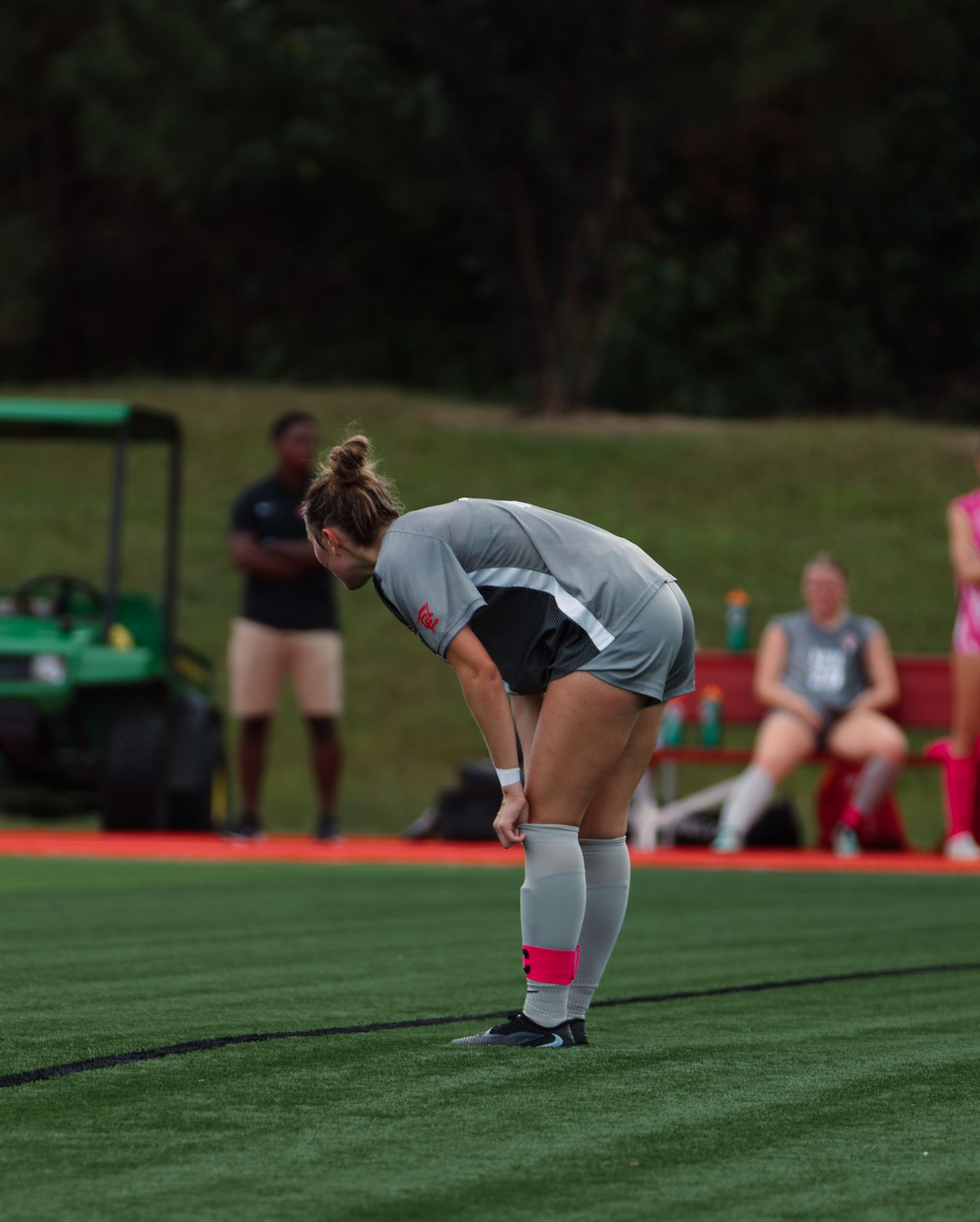 Soccer players performing stretching exercises on artificial turf field.