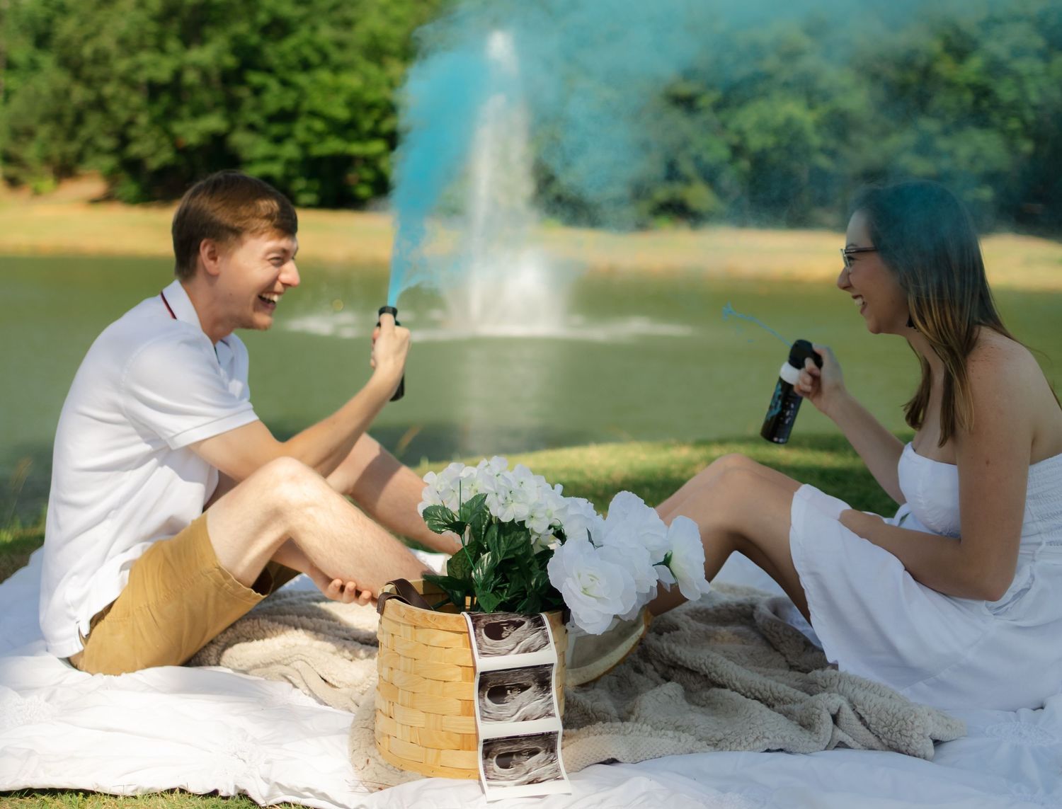 Couple having picnic on blanket while looking at ultrasound photos.