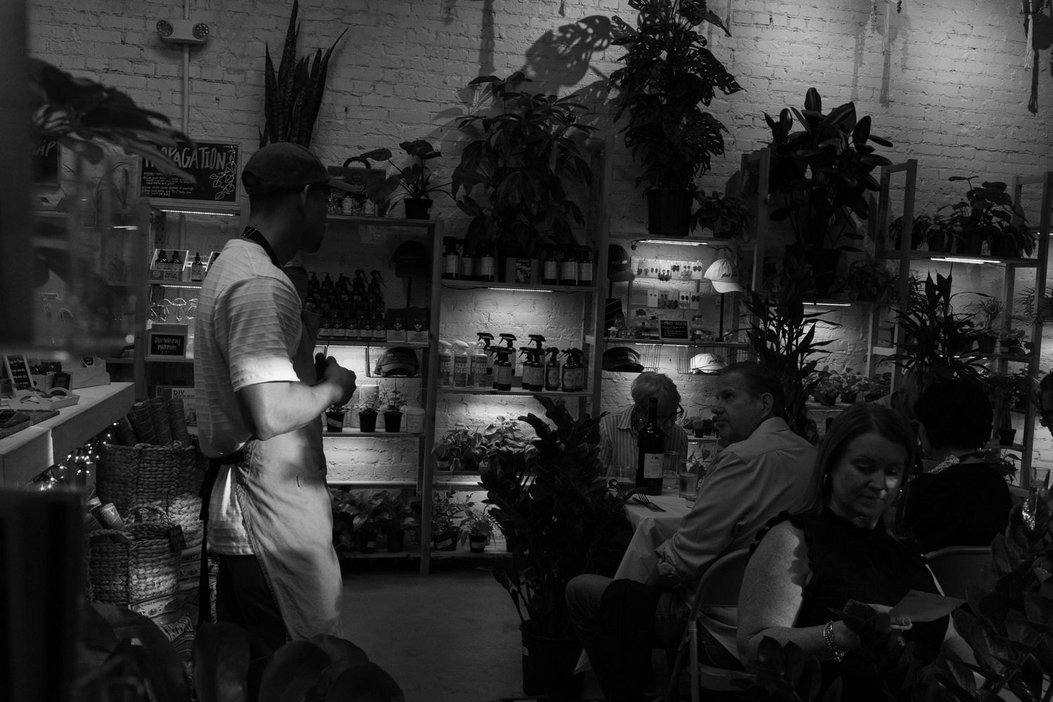 Moody black and white interior shot of a restaurant dining space with soft lighting.