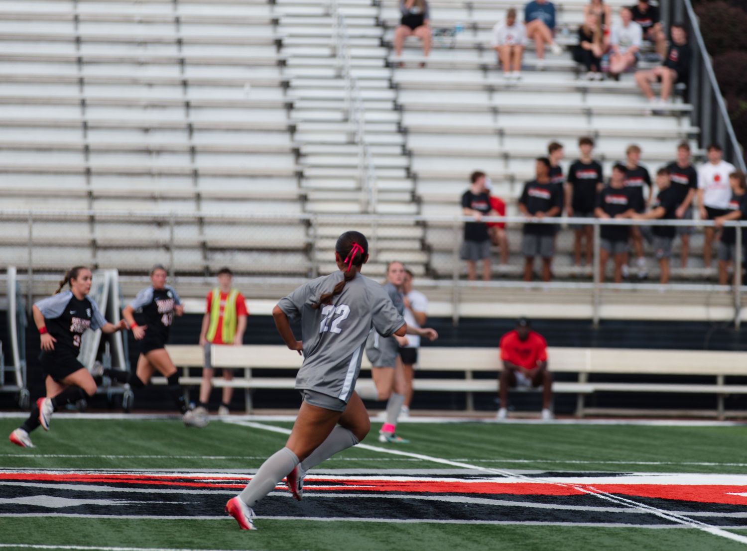 Soccer practice session taking place on field with stadium seating visible.