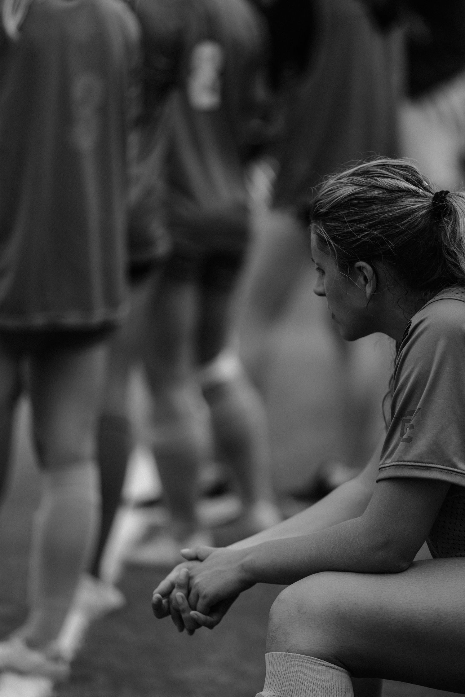 Athletes stretching and warming up on a sports field in black and white.