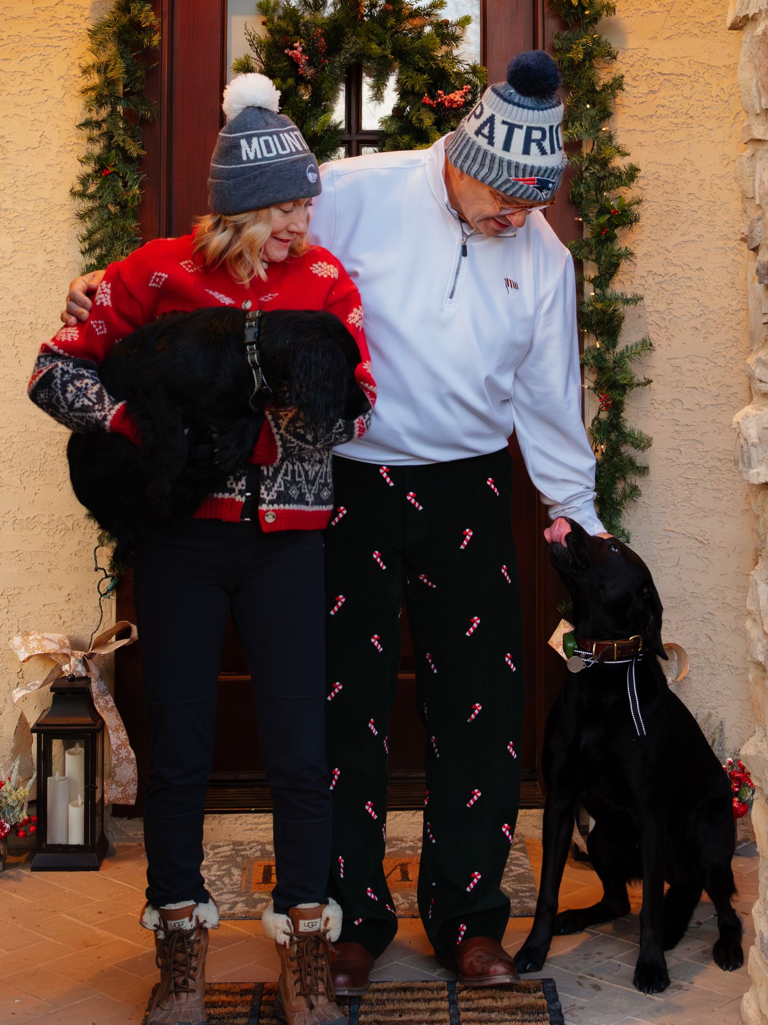 Holiday decorations frame a porch where two people sit together.