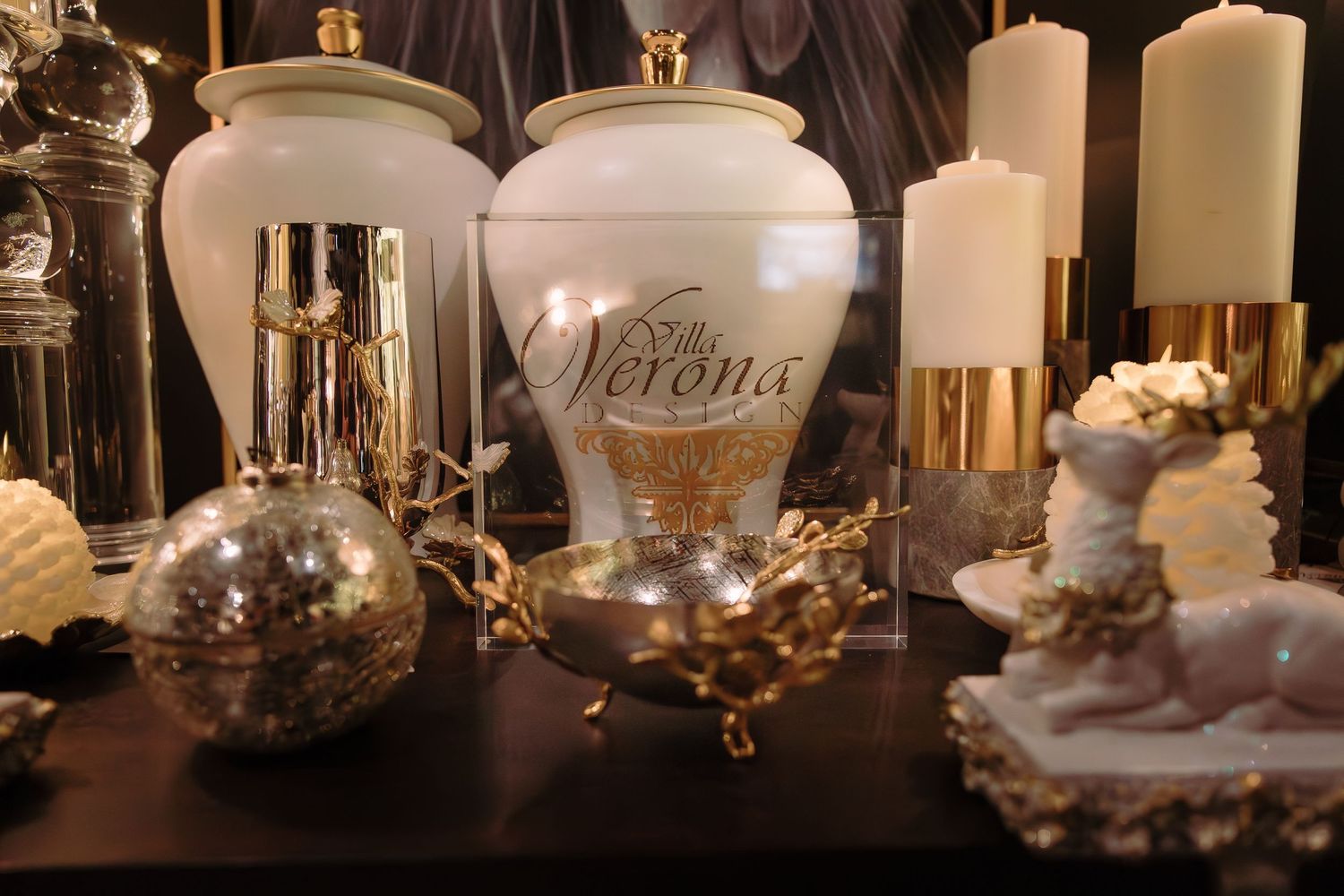 Elegant display of white candles and decorative glass vessels on a dark surface.