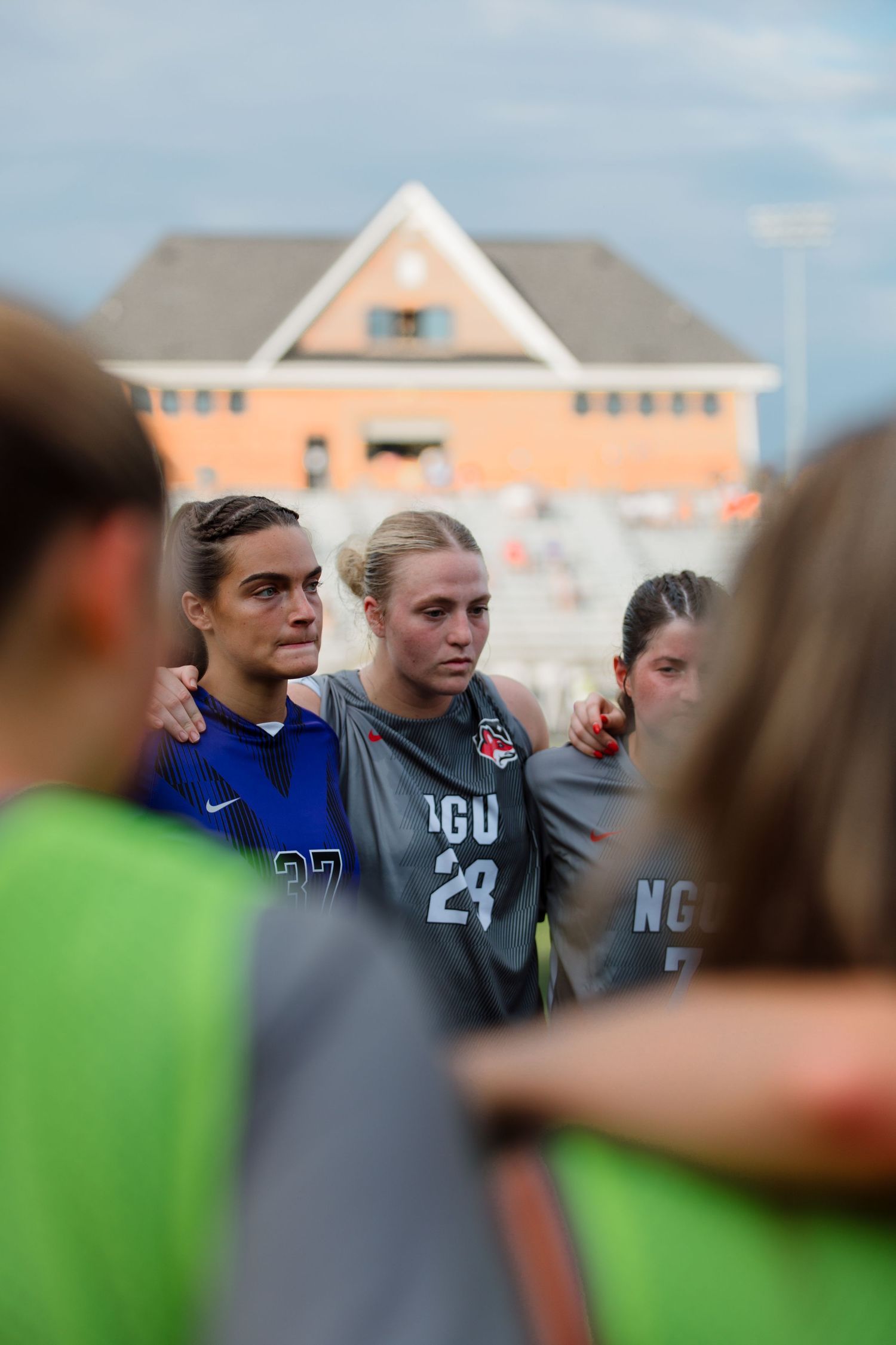 Soccer team members stand together for a pregame huddle.