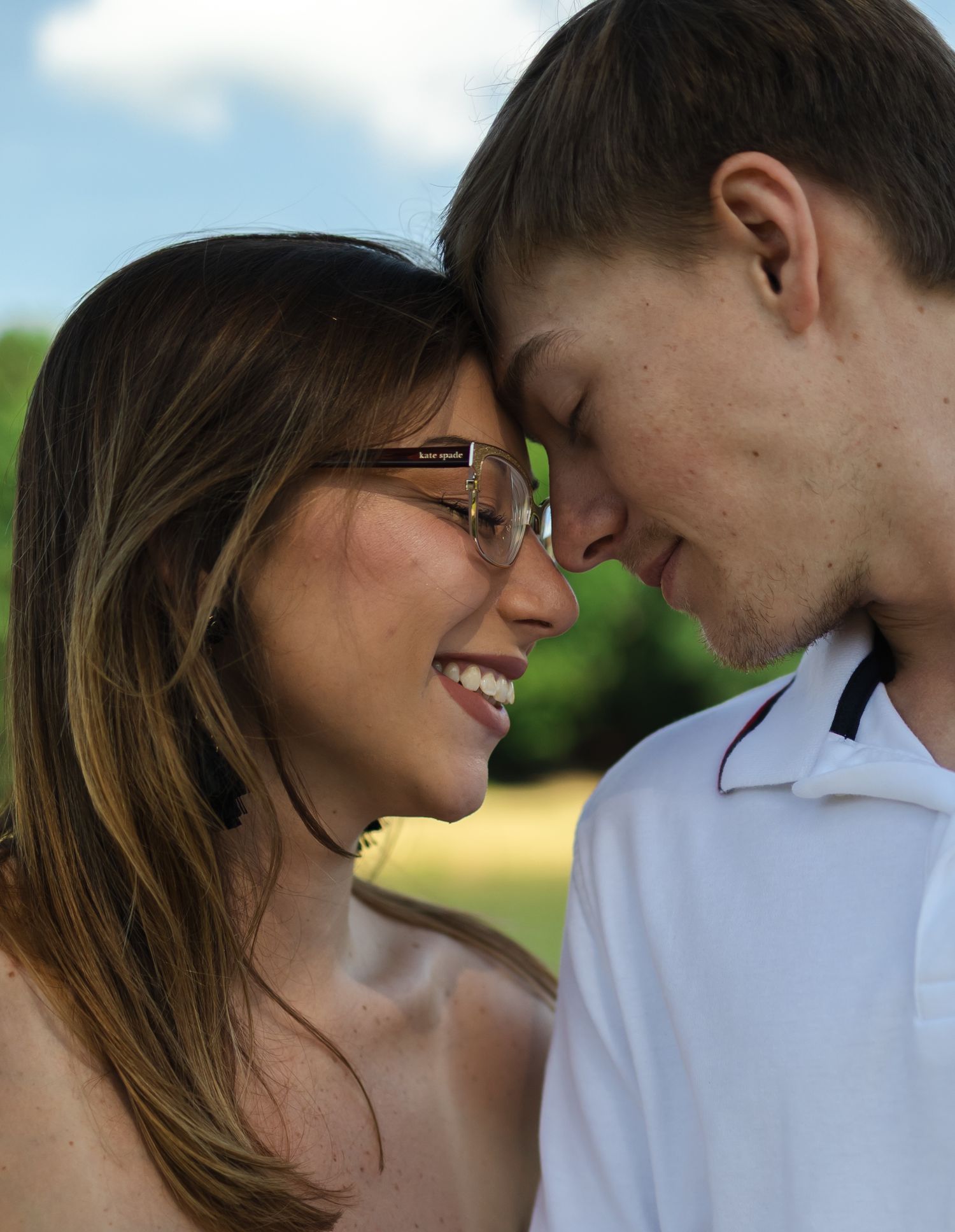 Romantic couple sharing tender moments in outdoor setting.
