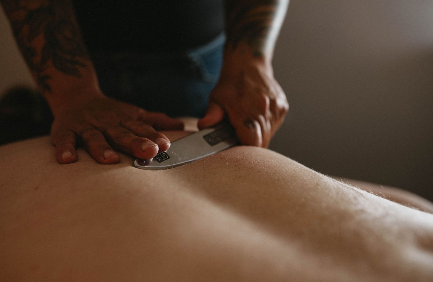 RMT applies therapeutic massage techniques on client's back in her clinic setting.