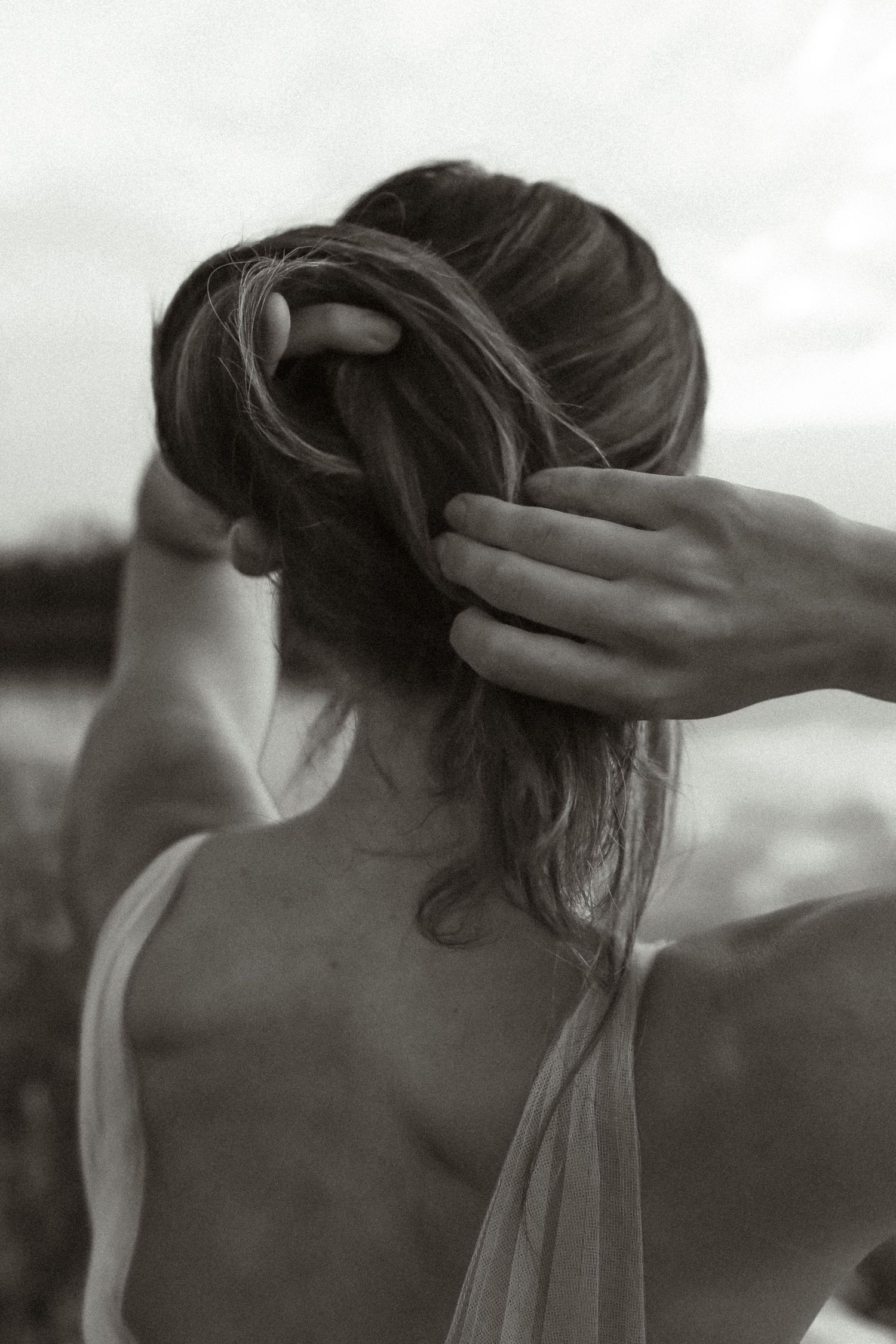 Artistic black and white photo showing hands gently holding and styling long flowing hair.